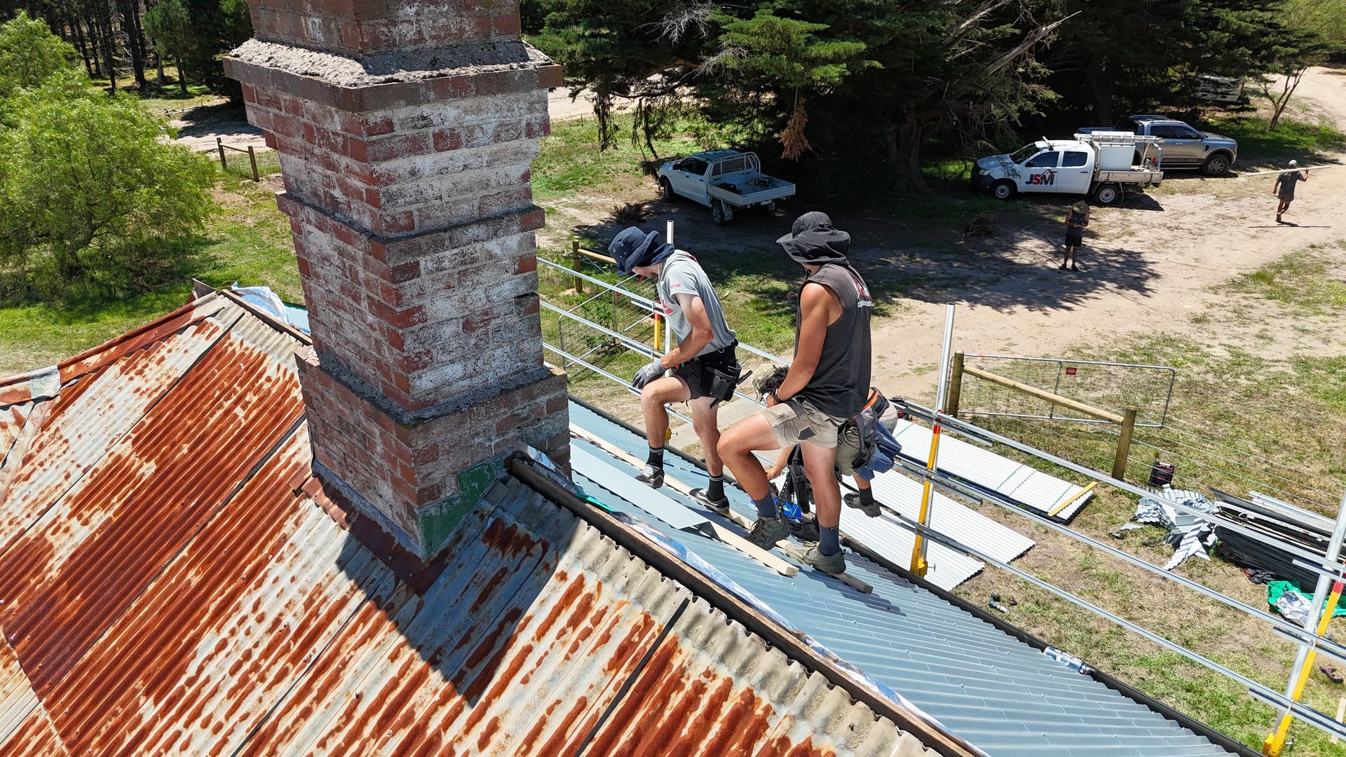 A close up of a black roof with trees in the background.