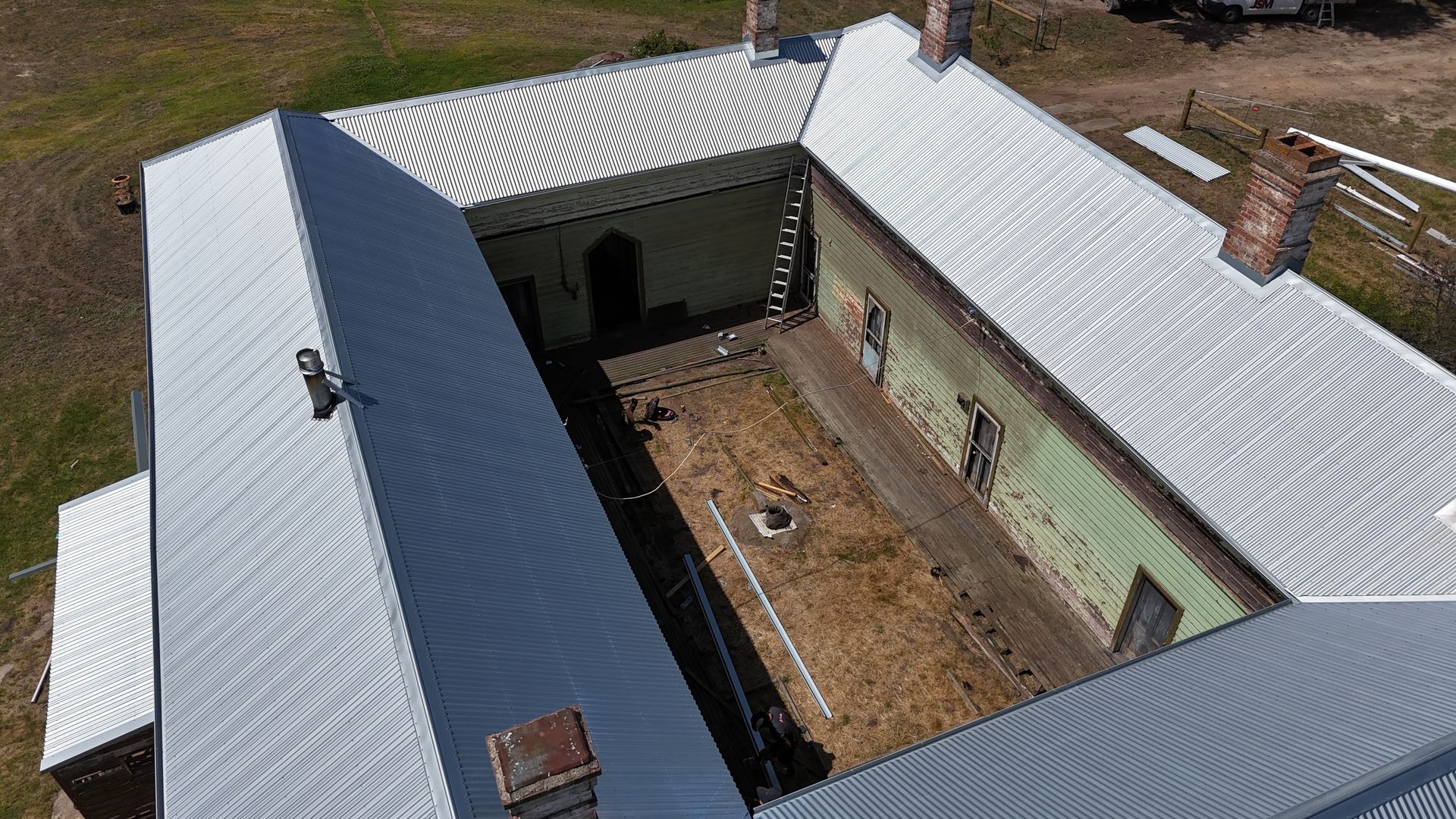 A black roof with a view of a city and trees.