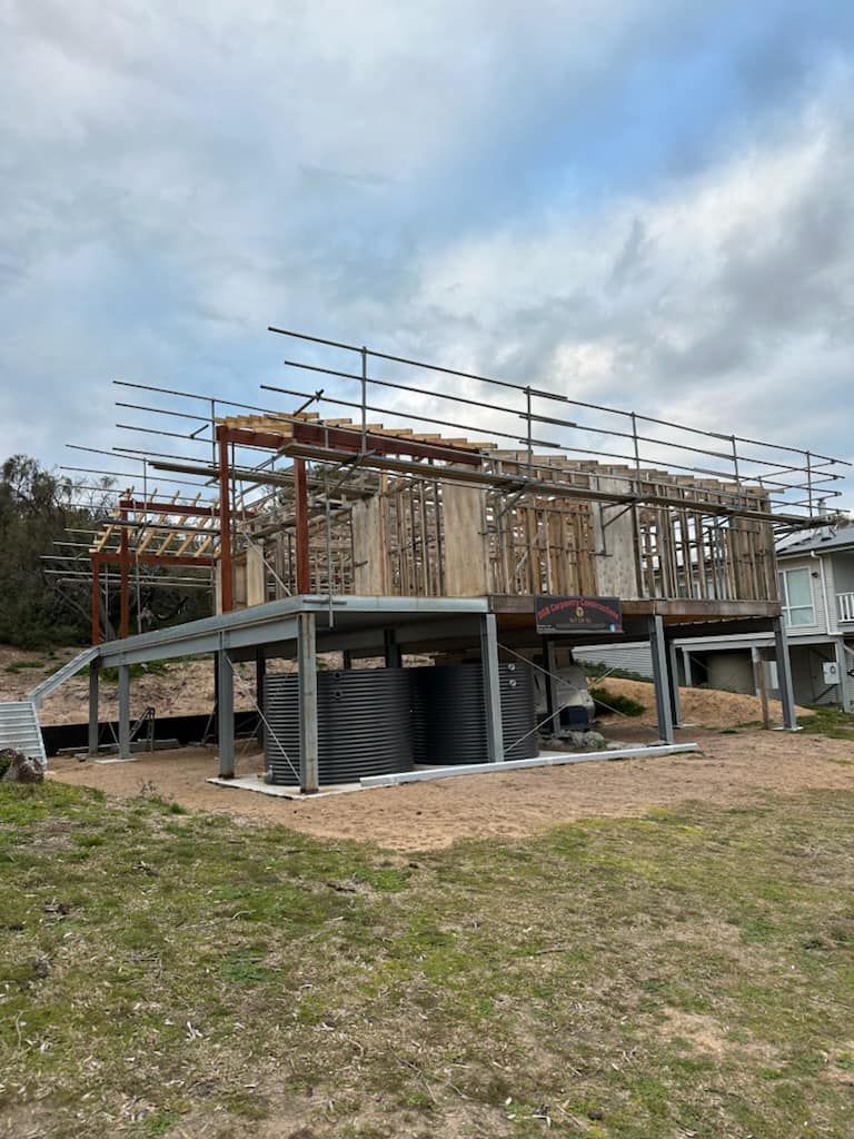 A house is being built in a field with a ramp.