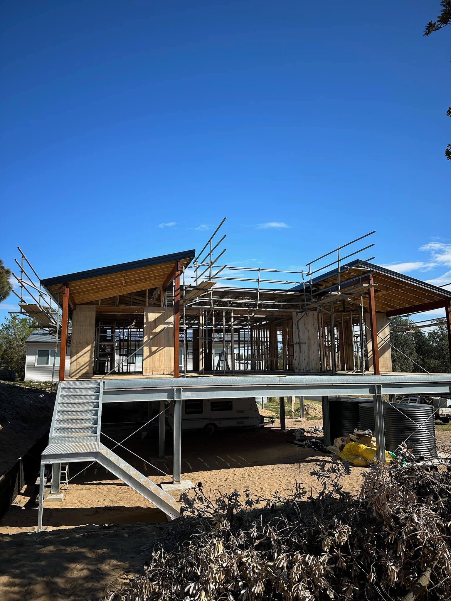 A house is being built on stilts with stairs leading up to it.