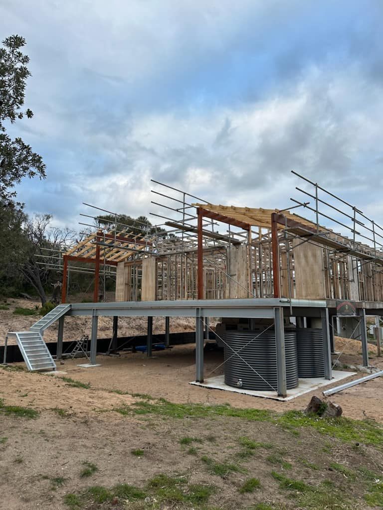 A house is being built with a large deck and stairs.