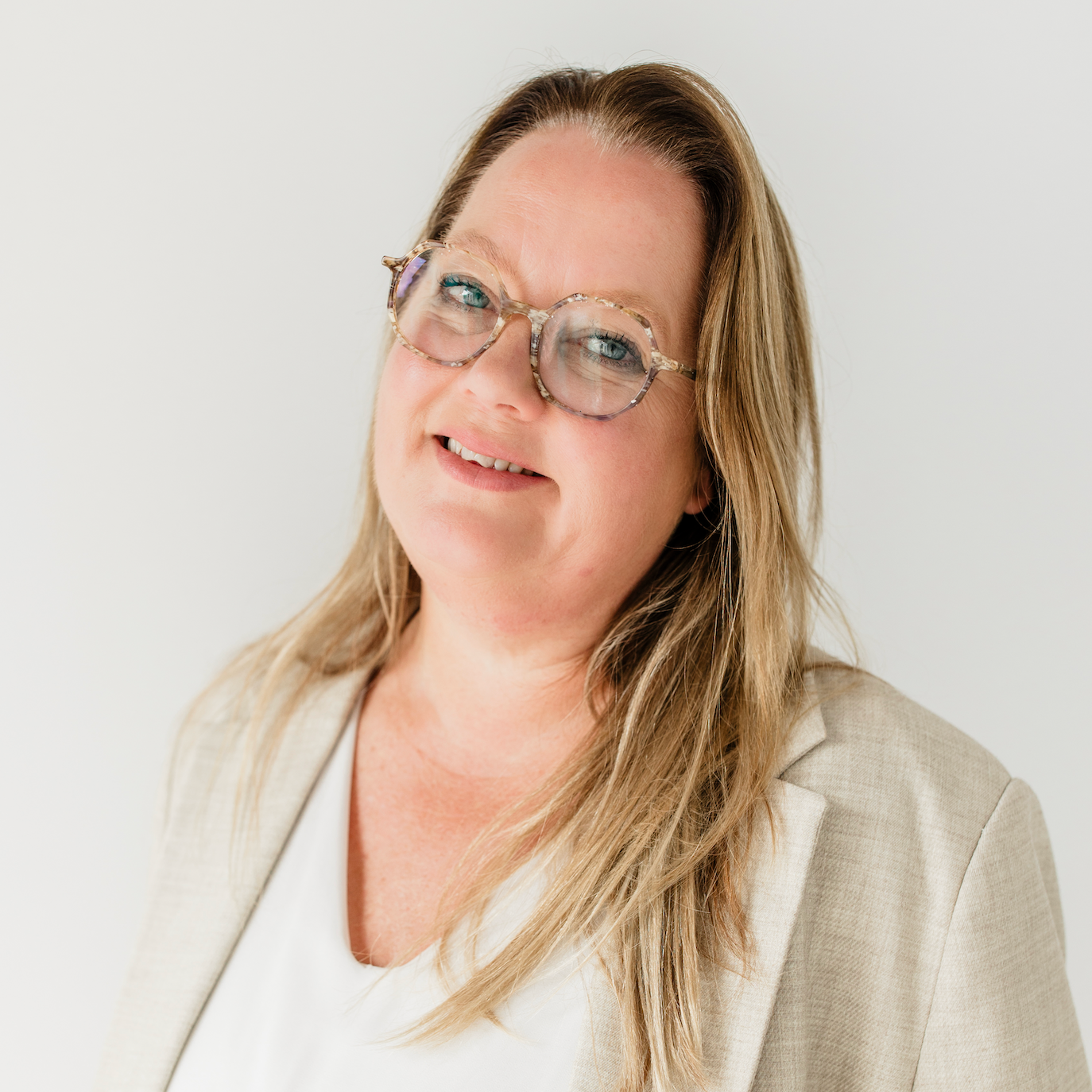 Een stel bezichtigt een huis met een makelaar in een lege keuken; ze glimlachen en kijken naar de makelaar.