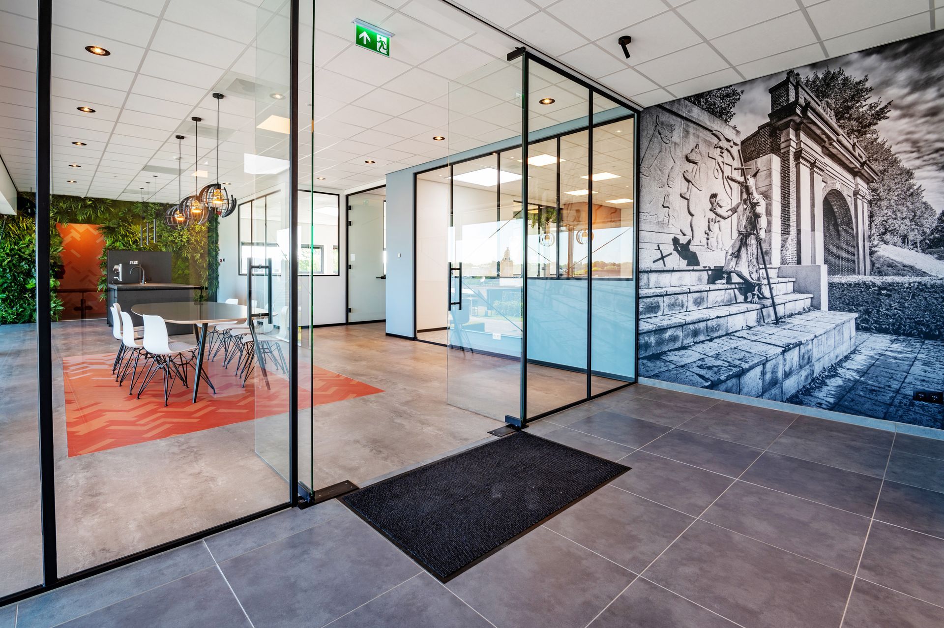 Modern kantoorinterieur met glazen wanden, vergadertafel en een grote muurschildering.