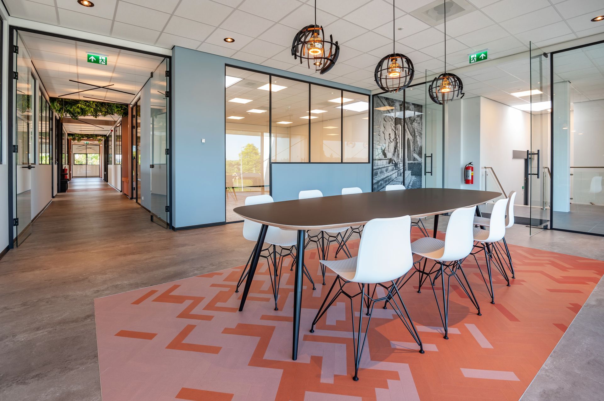 Moderne vergaderruimte met een lange tafel, stoelen en sfeerverlichting.