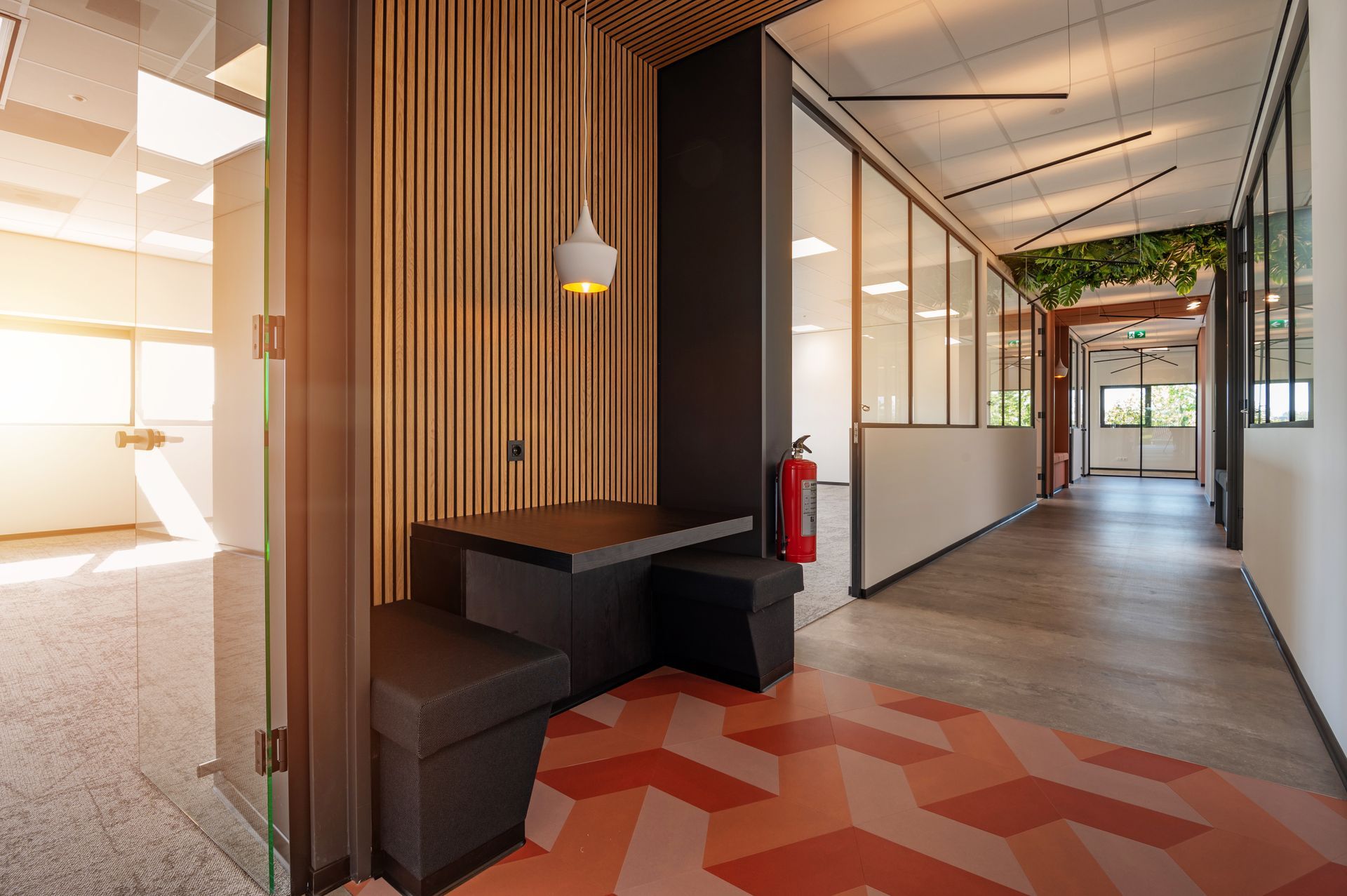 Moderne kantoorhal met houten lambrisering, zithoek en ruimtes met glazen wanden.