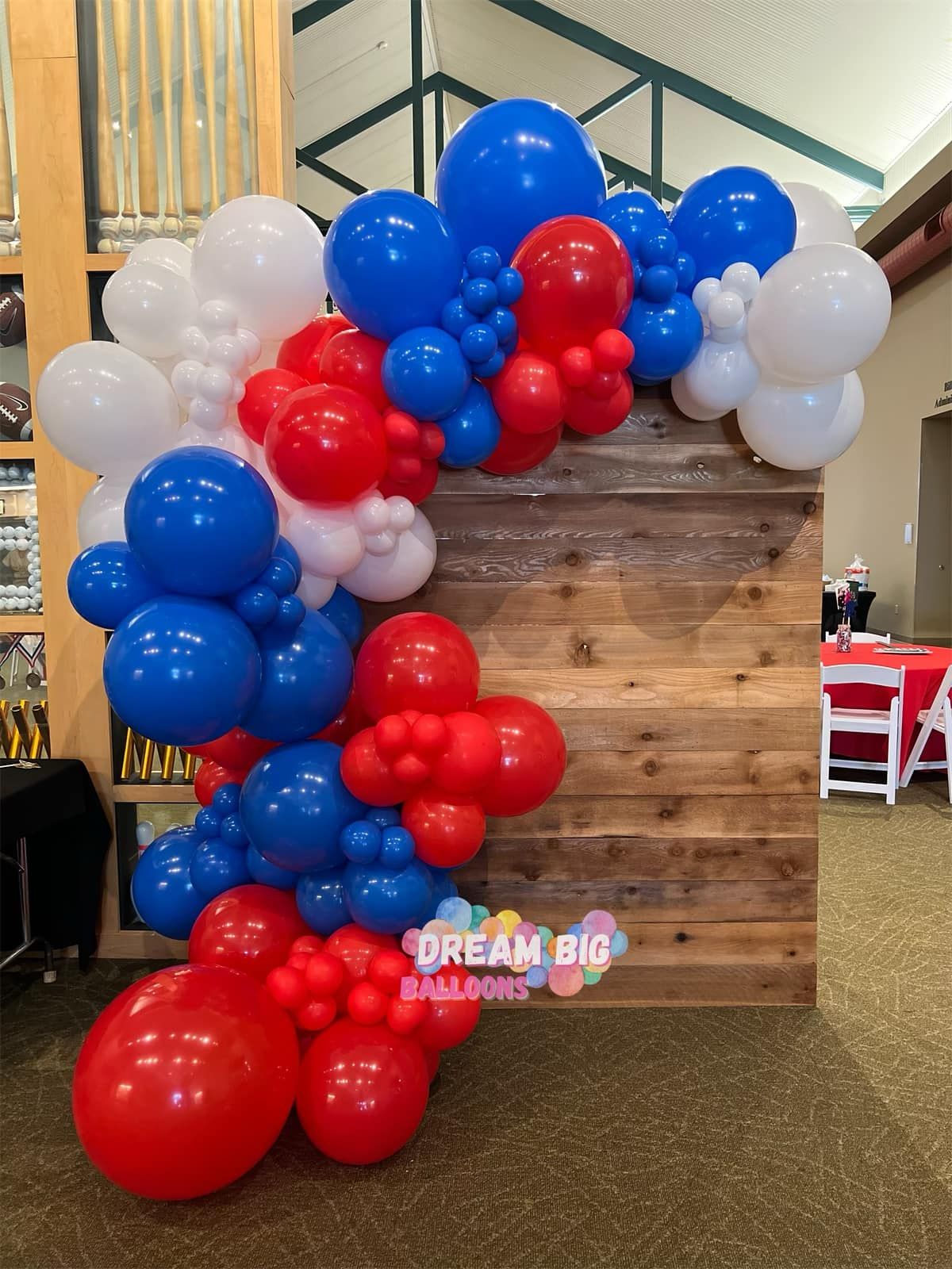 a wooden wall with red , white and blue balloons on it
