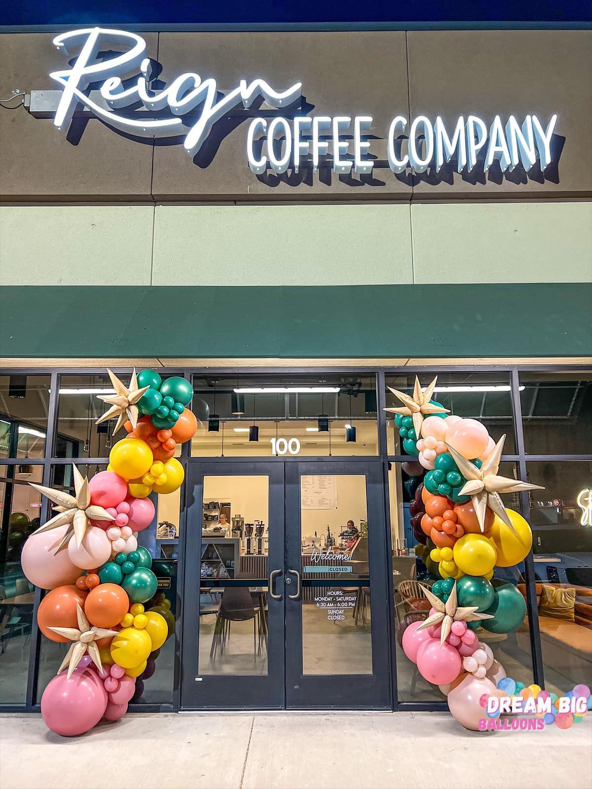 the front of a coffee company with balloons in front of it