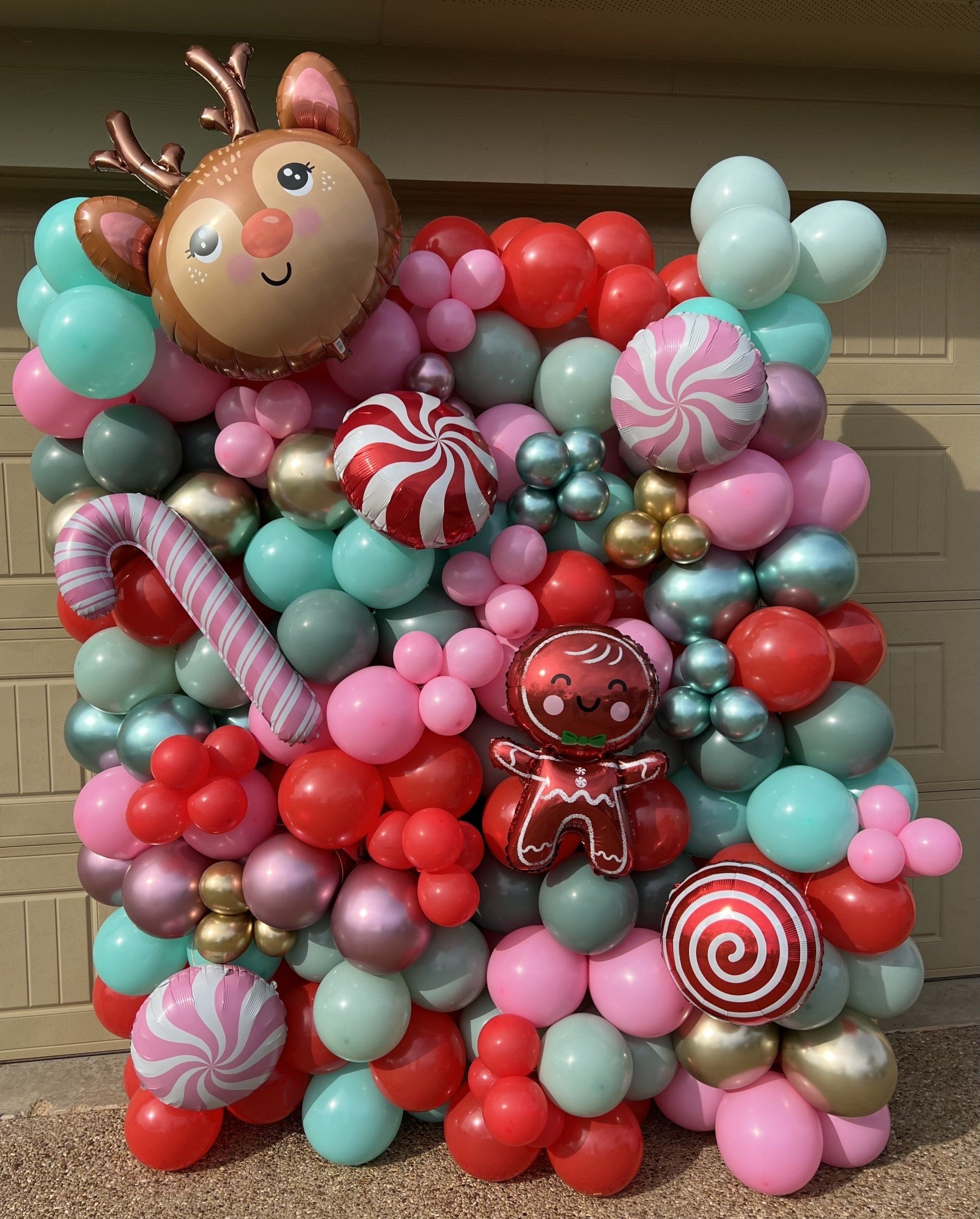 a bunch of balloons are sitting on top of each other on a wall