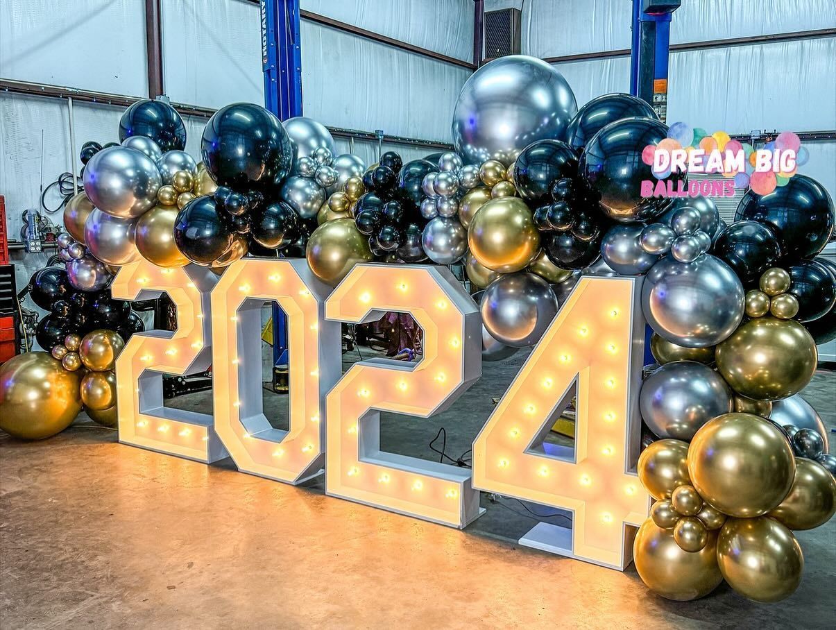 A large sign that says `` 2024 '' is surrounded by balloons.