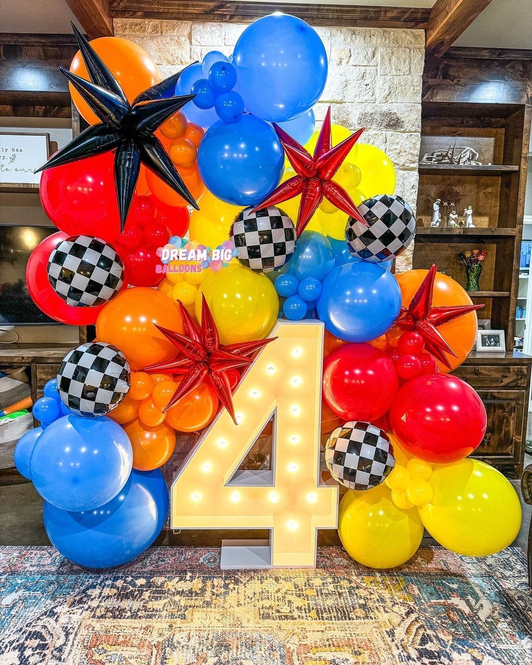 A room filled with balloons and a lighted number four.
