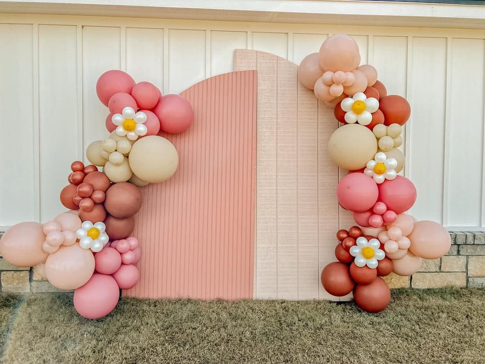 a bunch of balloons are sitting in front of a wall