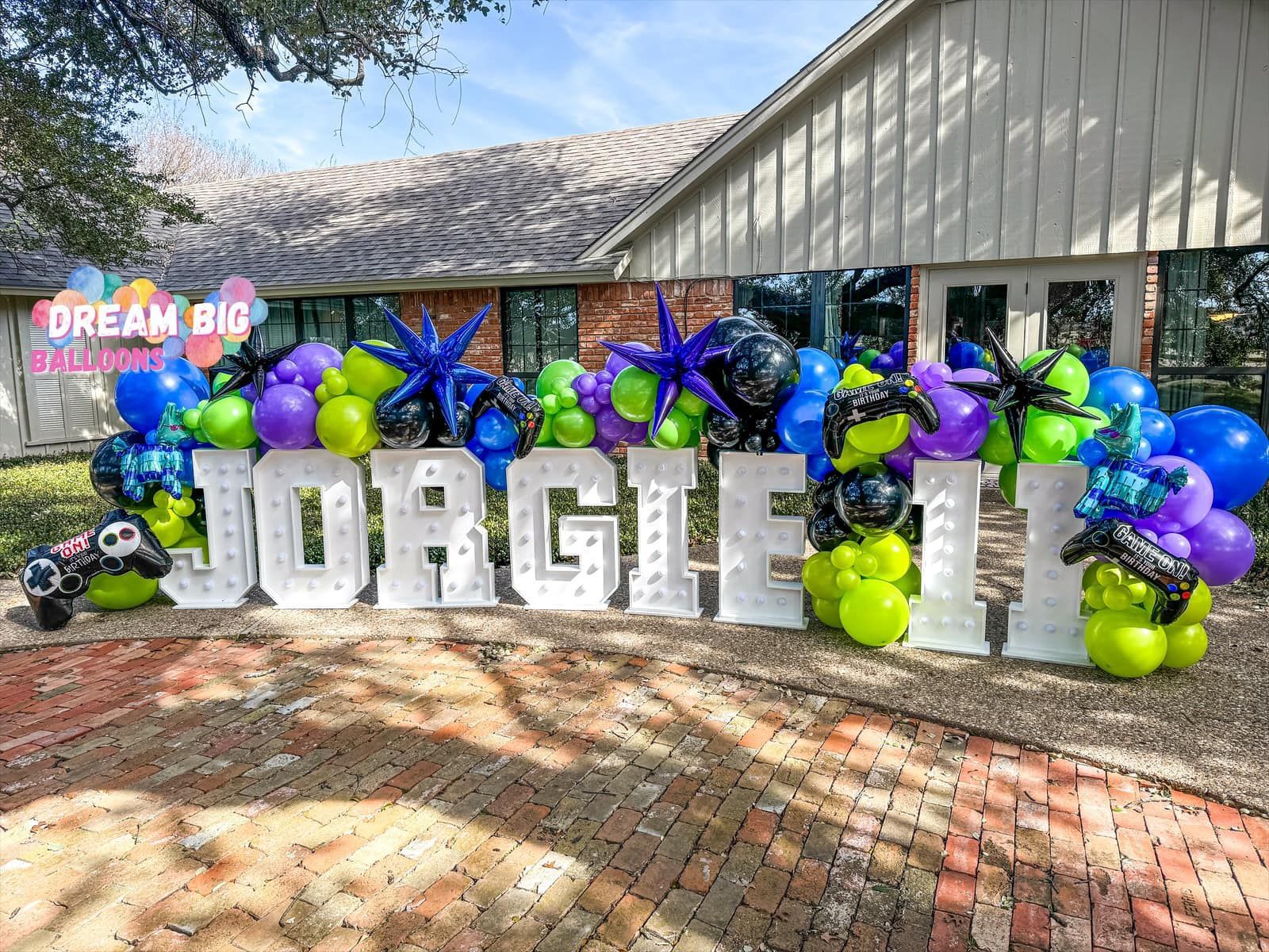 a bunch of balloons are sitting in front of a house