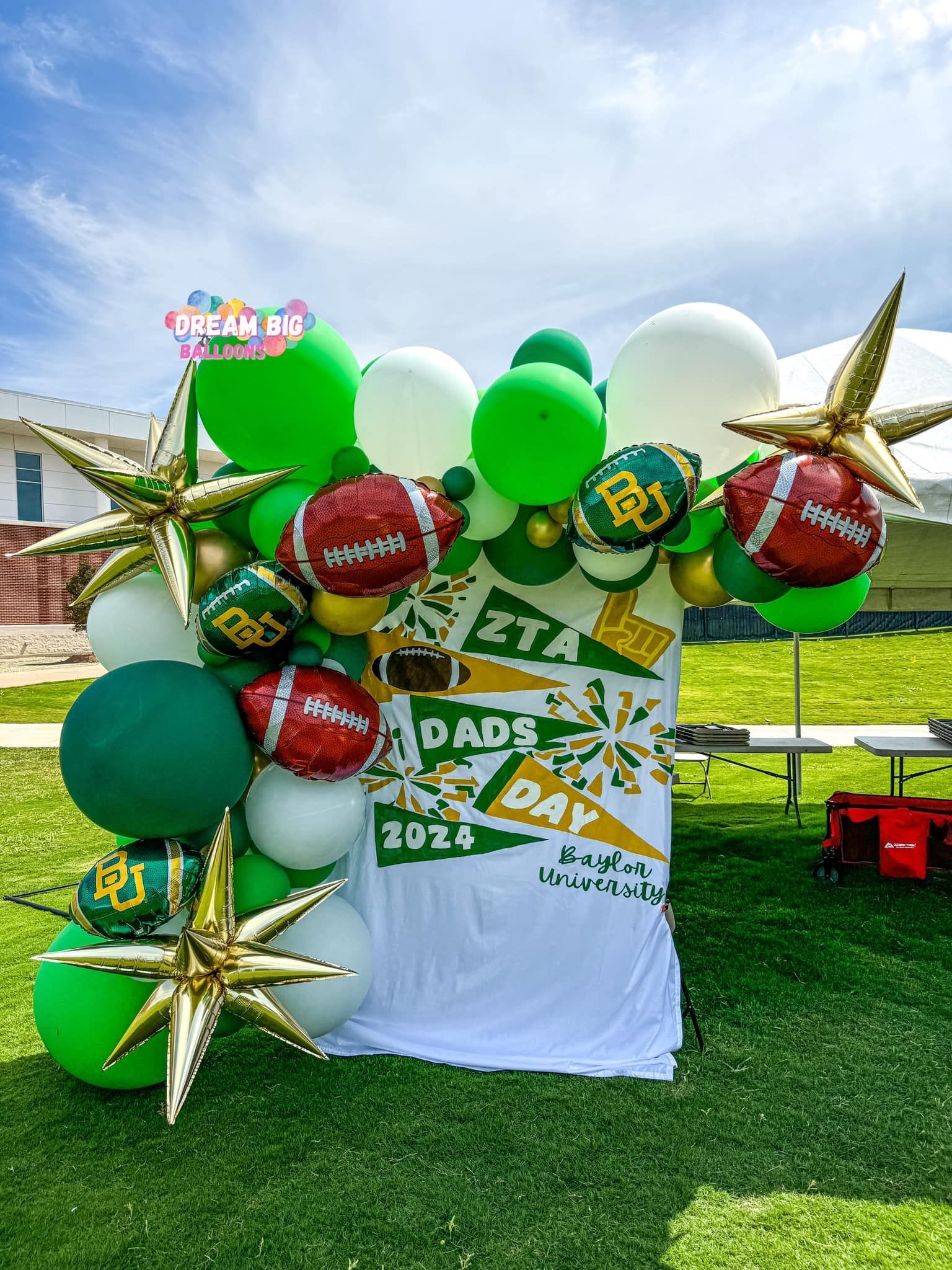A bunch of balloons are sitting on top of a table in a field.