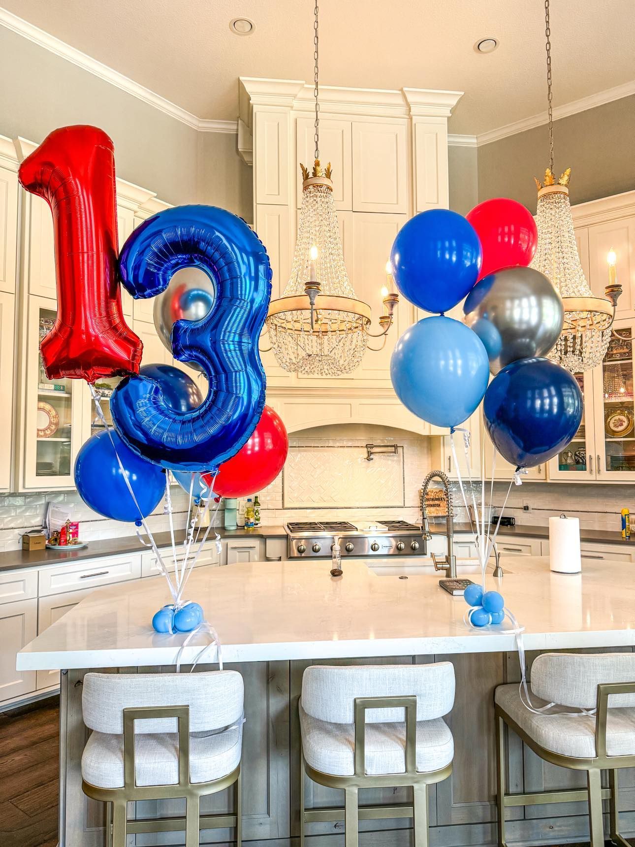 A kitchen with a bunch of balloons on the counter.