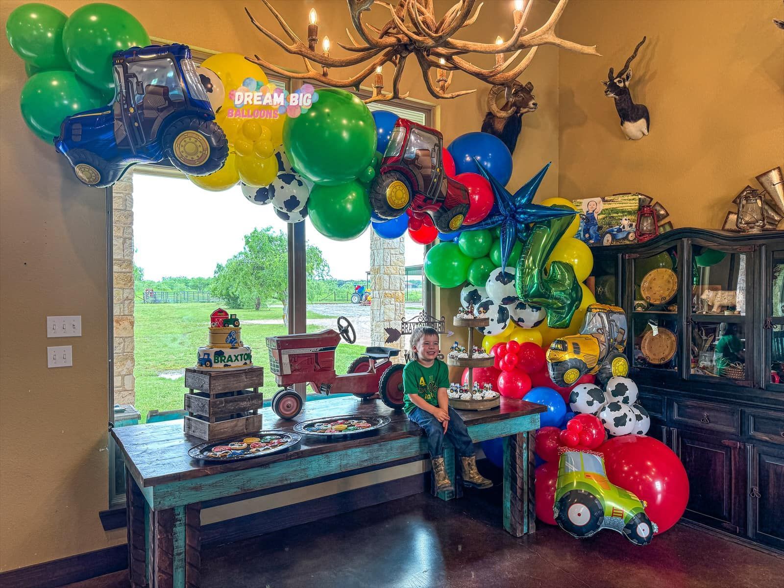 A room decorated with balloons and tractors for a birthday party.