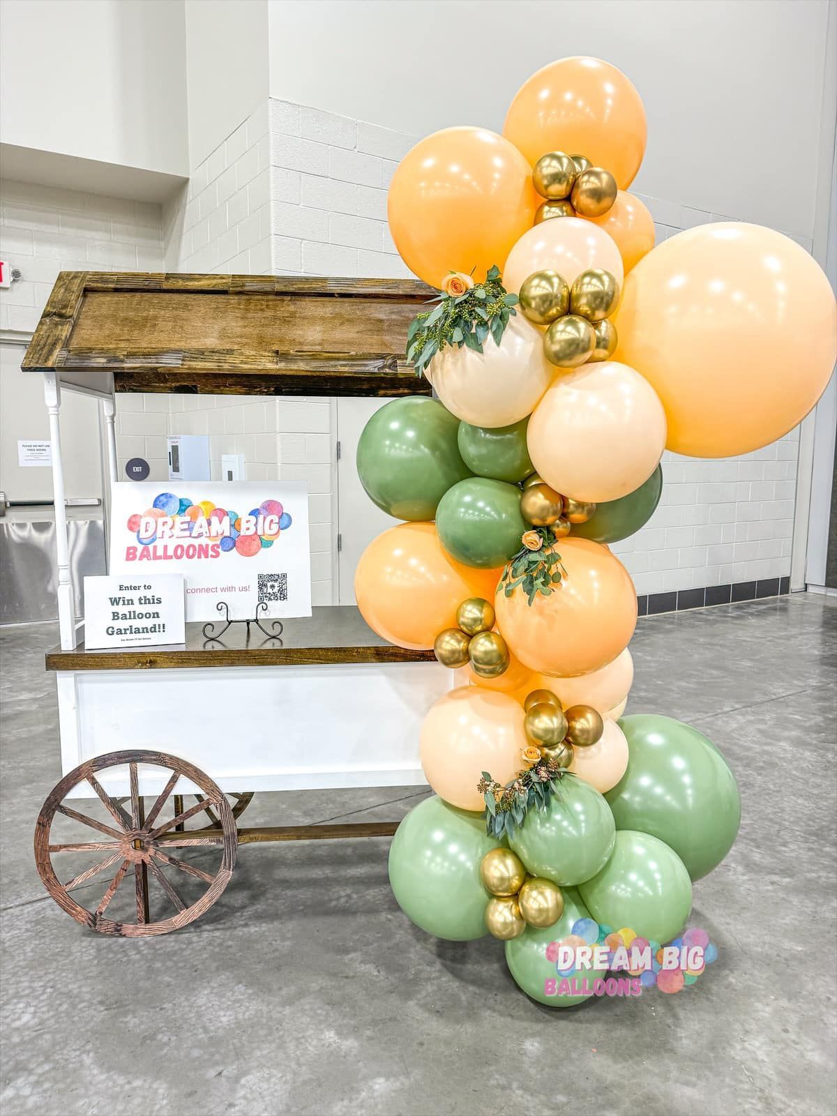 a cart is decorated with balloons and a garland of balloons