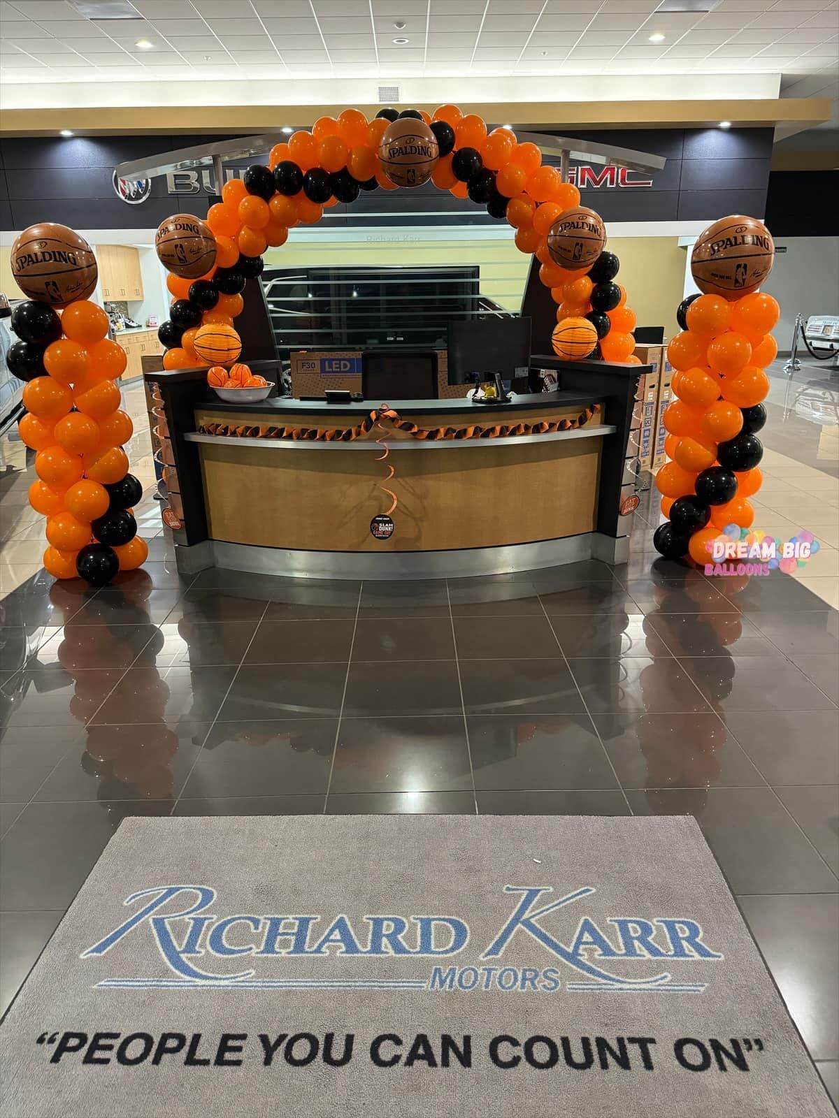 A richard carr dealership is decorated for halloween with balloons and pumpkins.