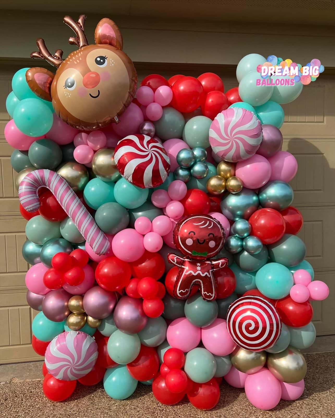 A bunch of balloons are sitting on top of each other on a wall.