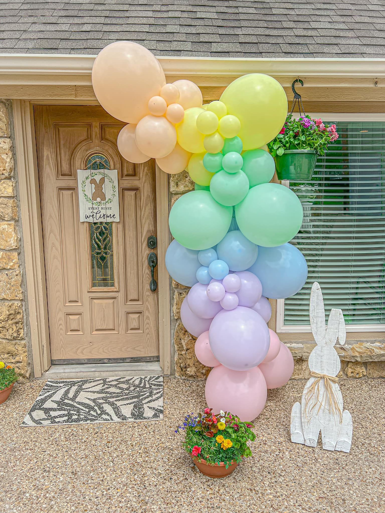a bunch of balloons are sitting in front of a house