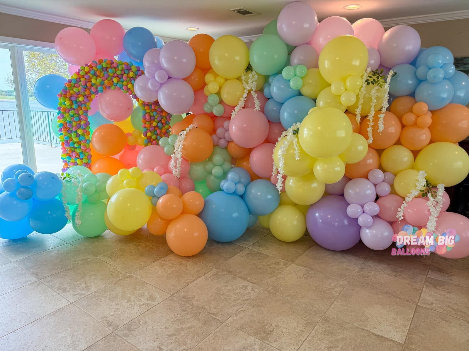 A room filled with lots of colorful balloons. easter balloon wall with floral and easter eggs