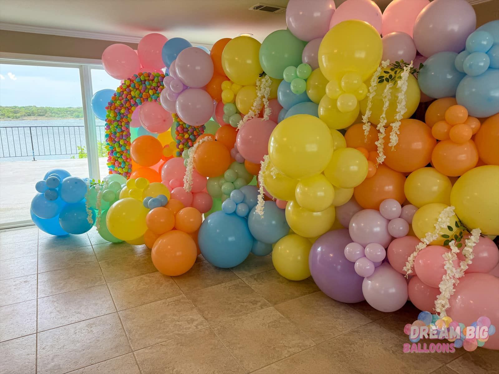 A bunch of colorful balloons are sitting on the floor in a room.