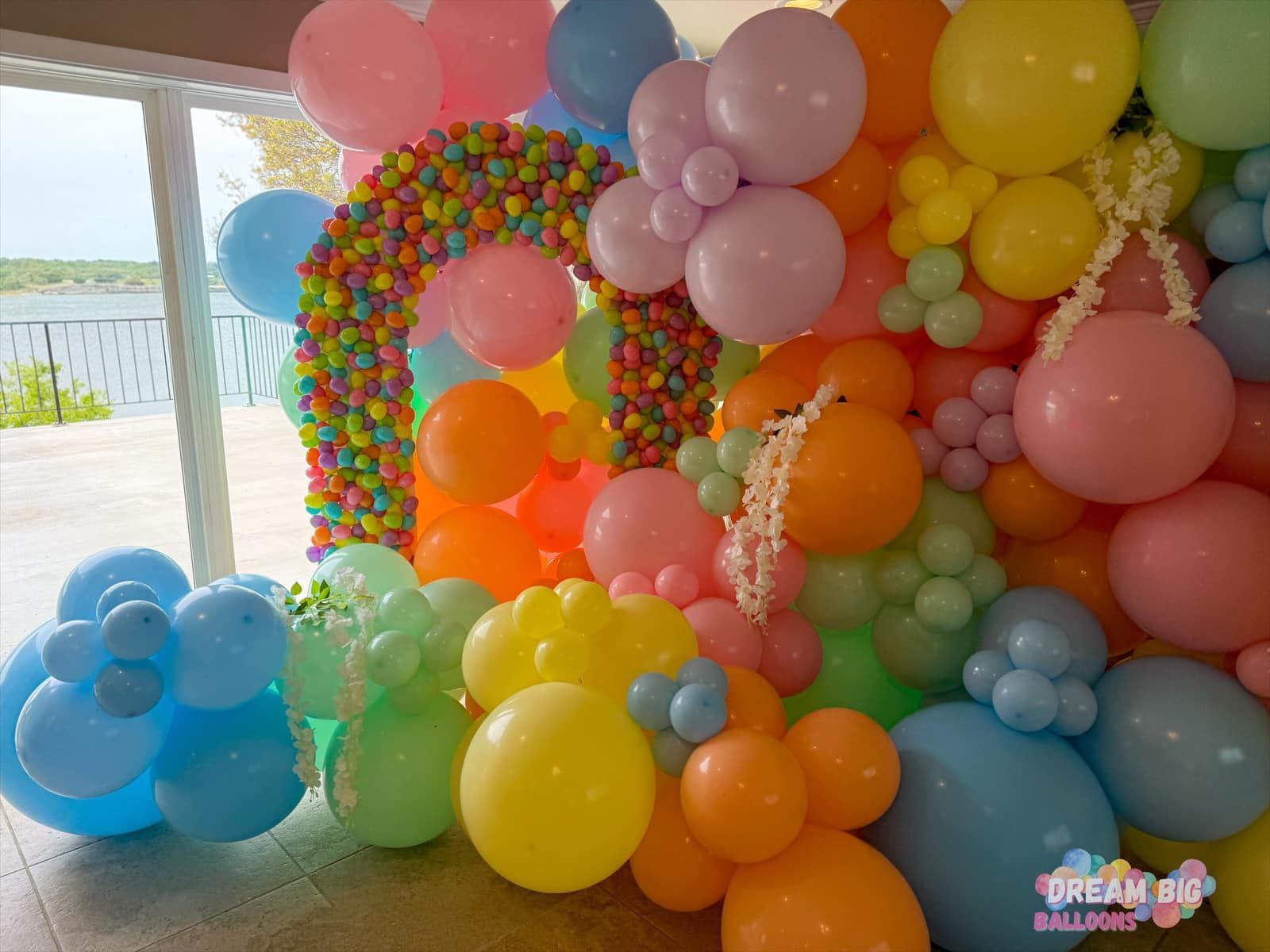 A bunch of colorful balloons are sitting on the floor in a room.