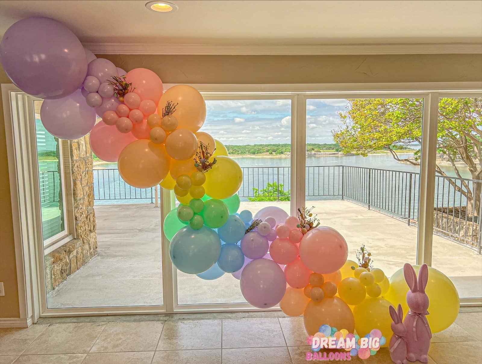 A bunch of balloons are hanging from a window in a room.