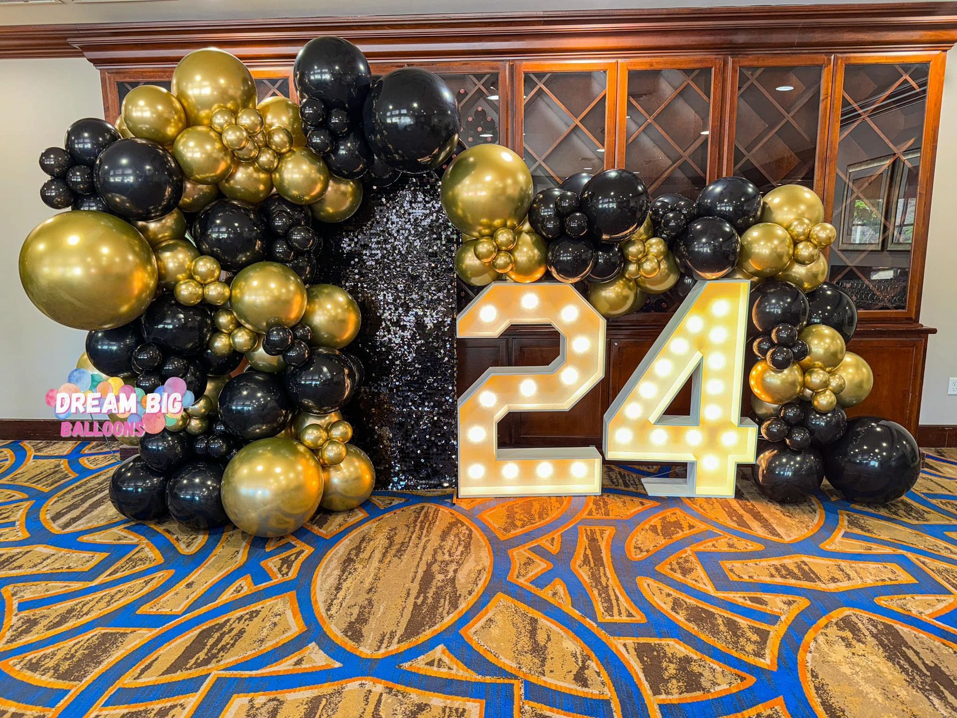 A room filled with balloons and a sign that says `` 24 ''.