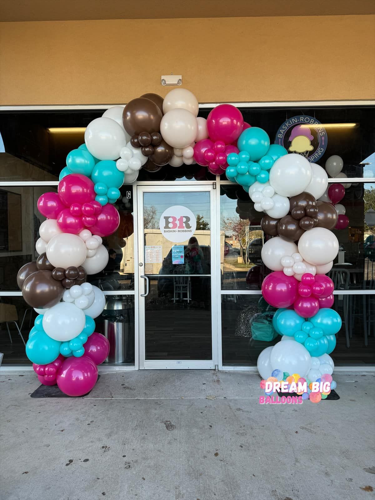 a large arch of balloons is in front of a store