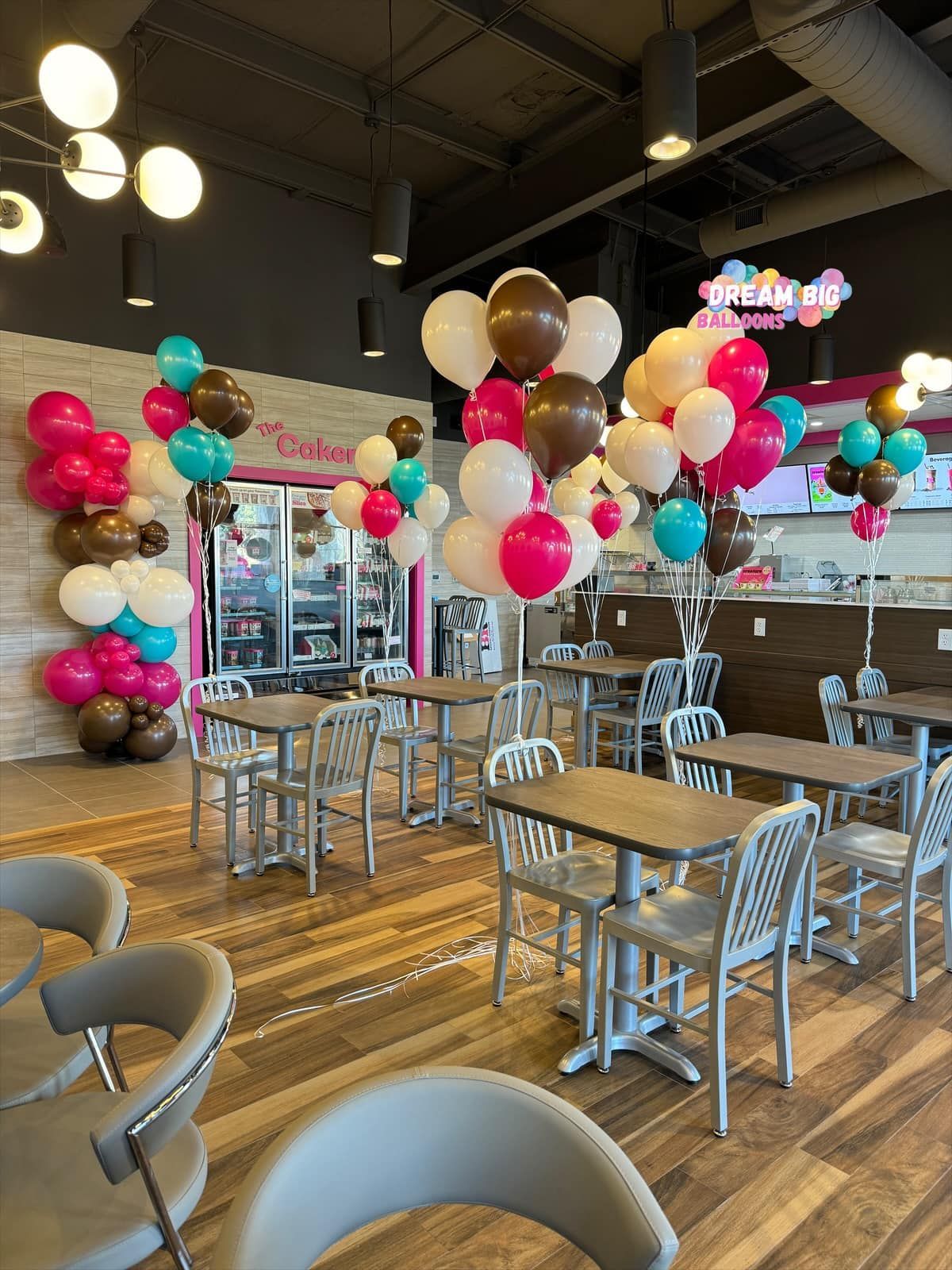 a restaurant with tables and chairs decorated with balloons