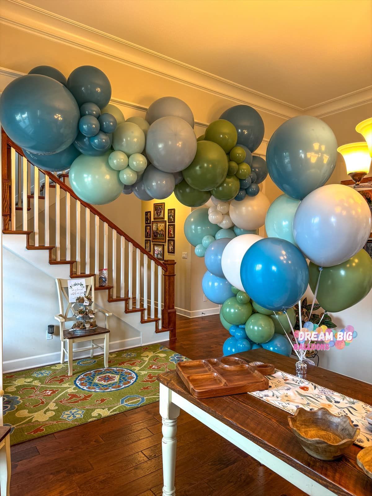 A bunch of balloons are hanging from the ceiling in a living room.
