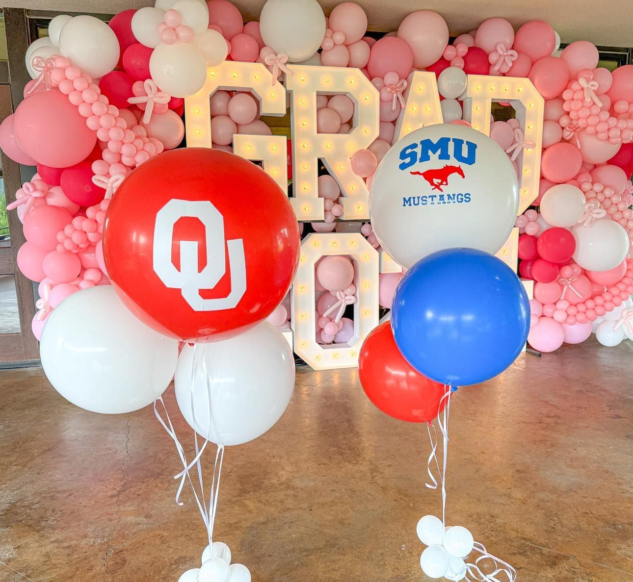 A bunch of balloons in front of a sign that says graduation