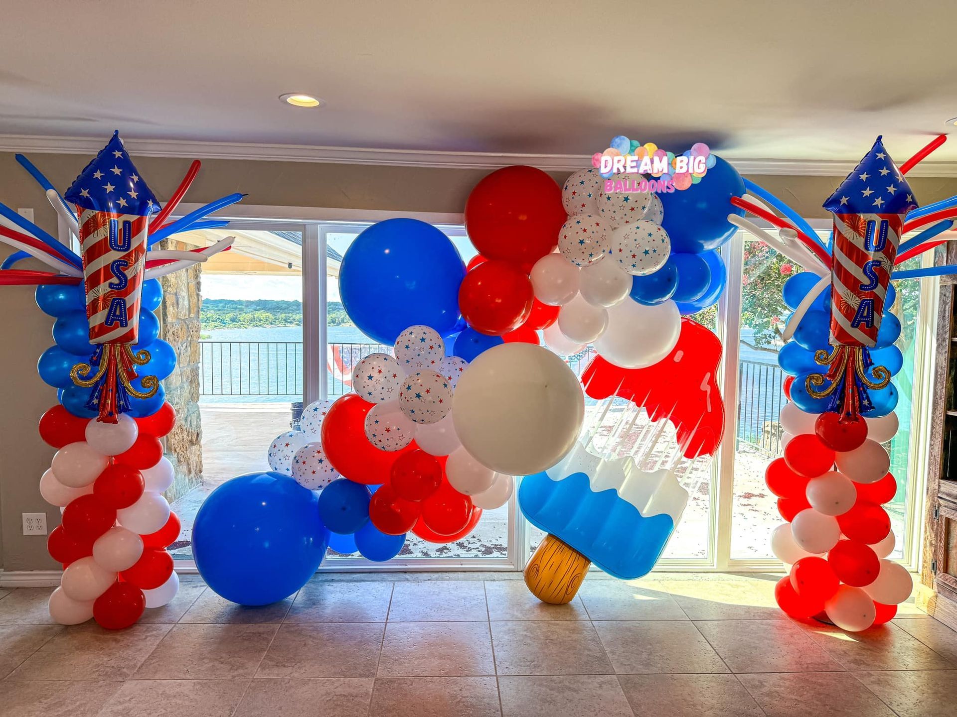 A room decorated with red , white and blue balloons and fireworks.