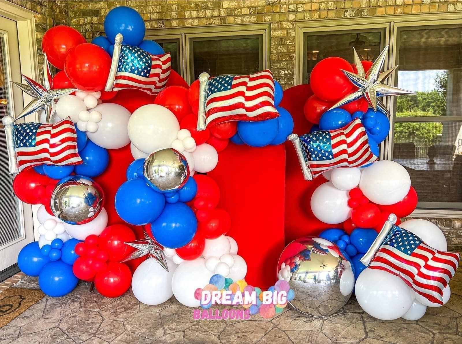 A bunch of red , white and blue balloons with american flags on them
