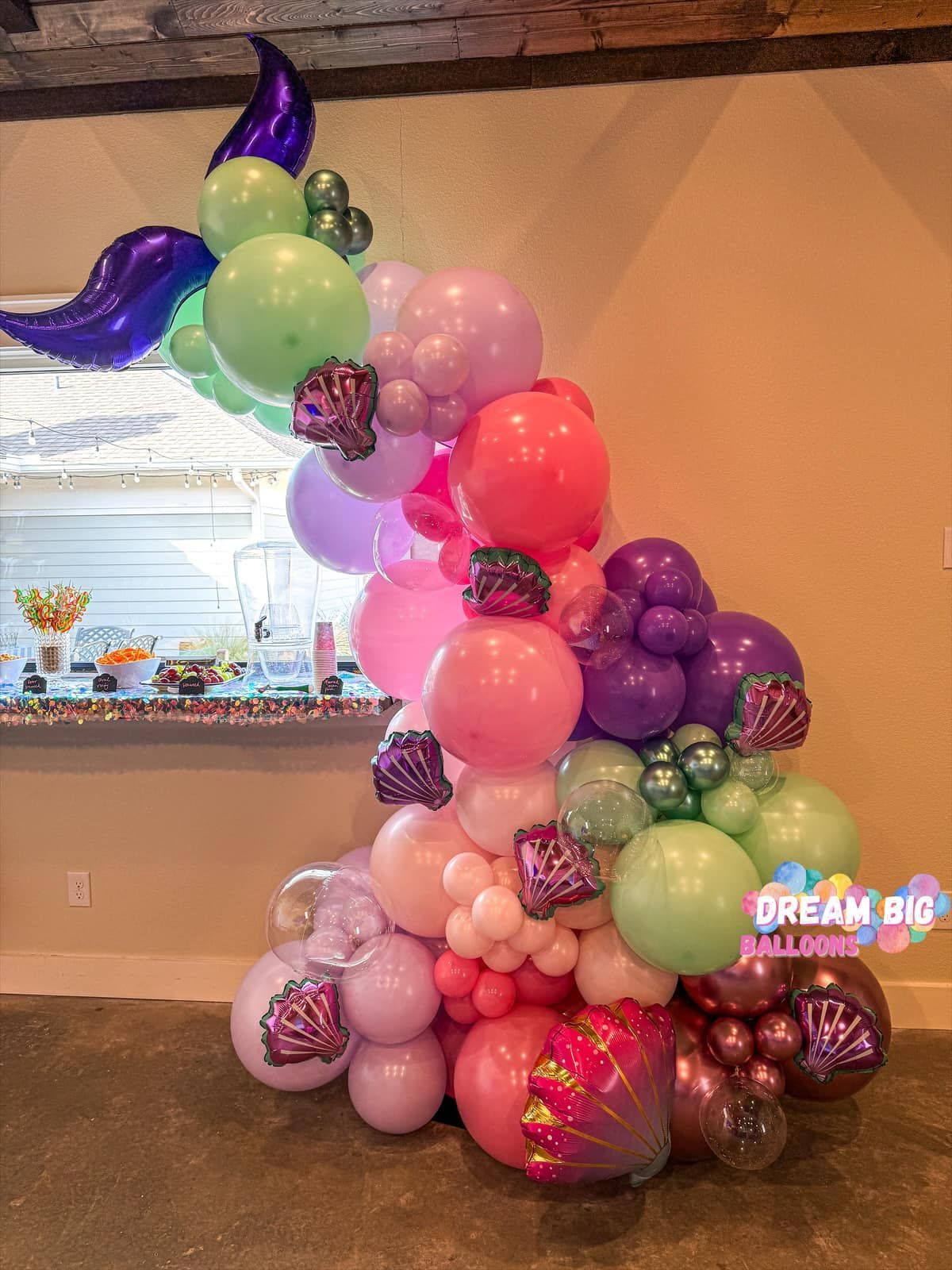 a bunch of balloons are stacked on top of each other in a room
