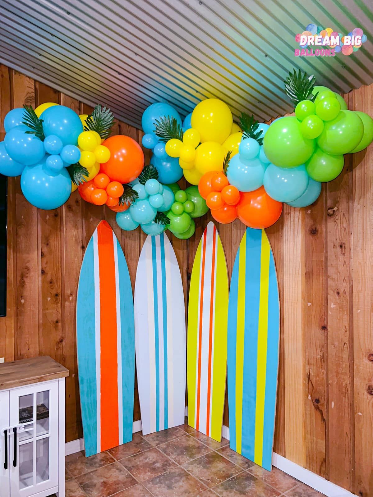 a room with surfboards and balloons on the wall