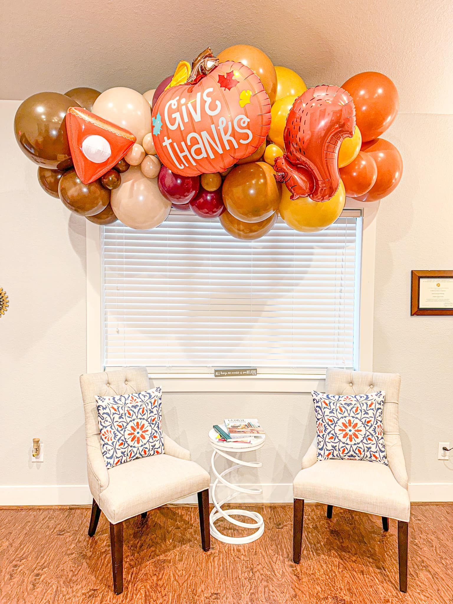 A room with two chairs and balloons hanging from the ceiling.