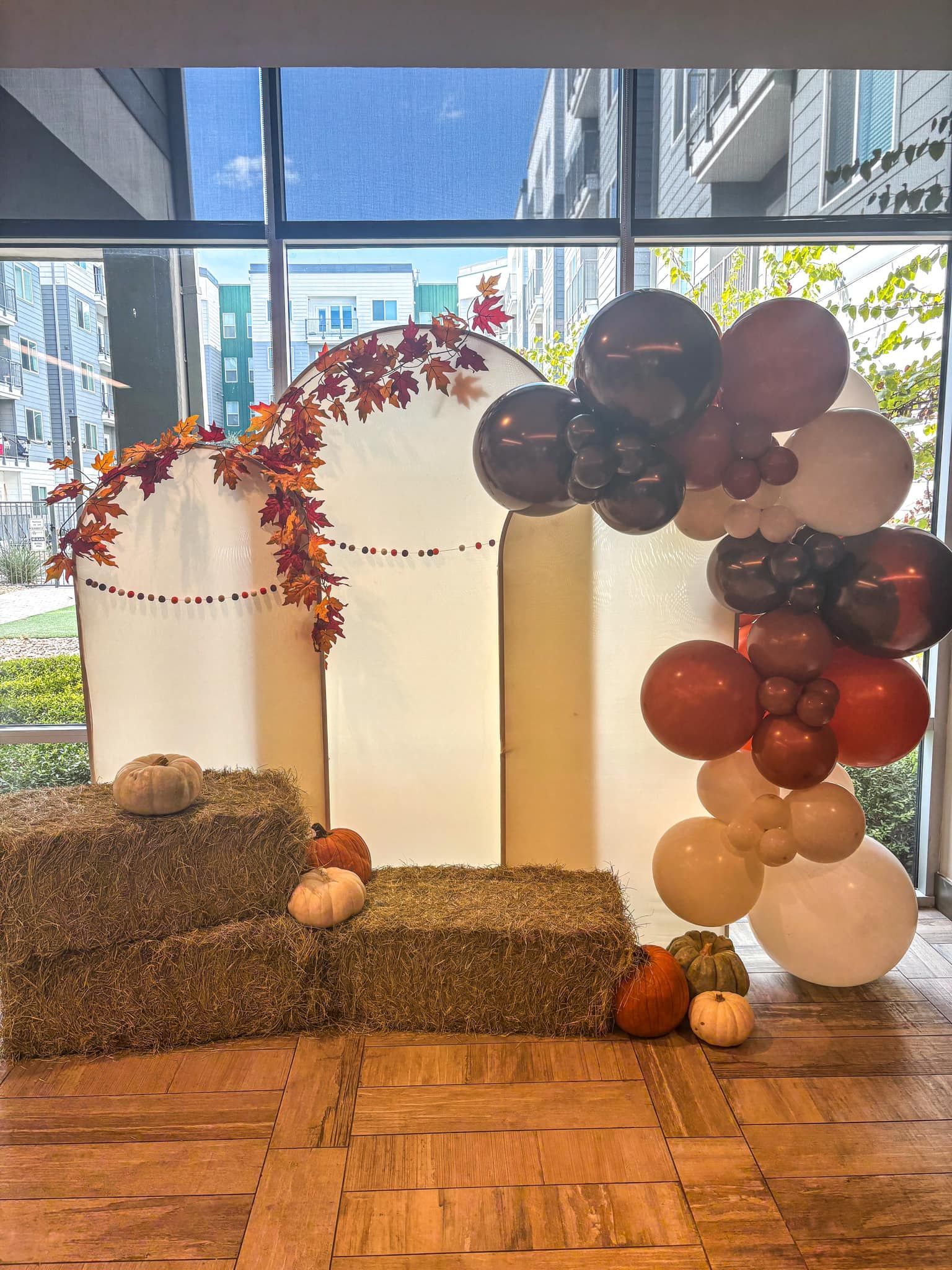 A room filled with hay bales , pumpkins , and balloons.
