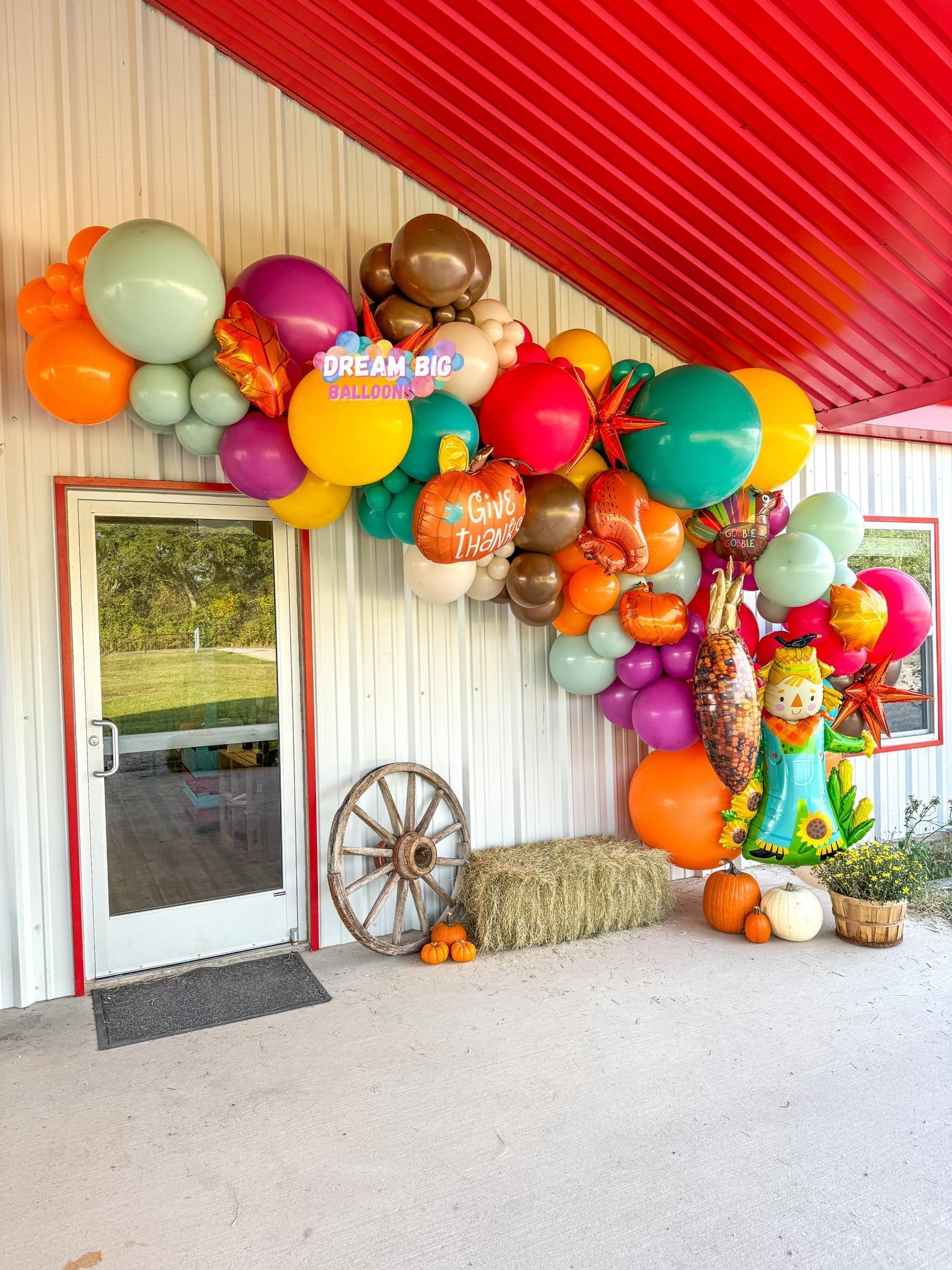 A bunch of balloons are hanging from the side of a building.
