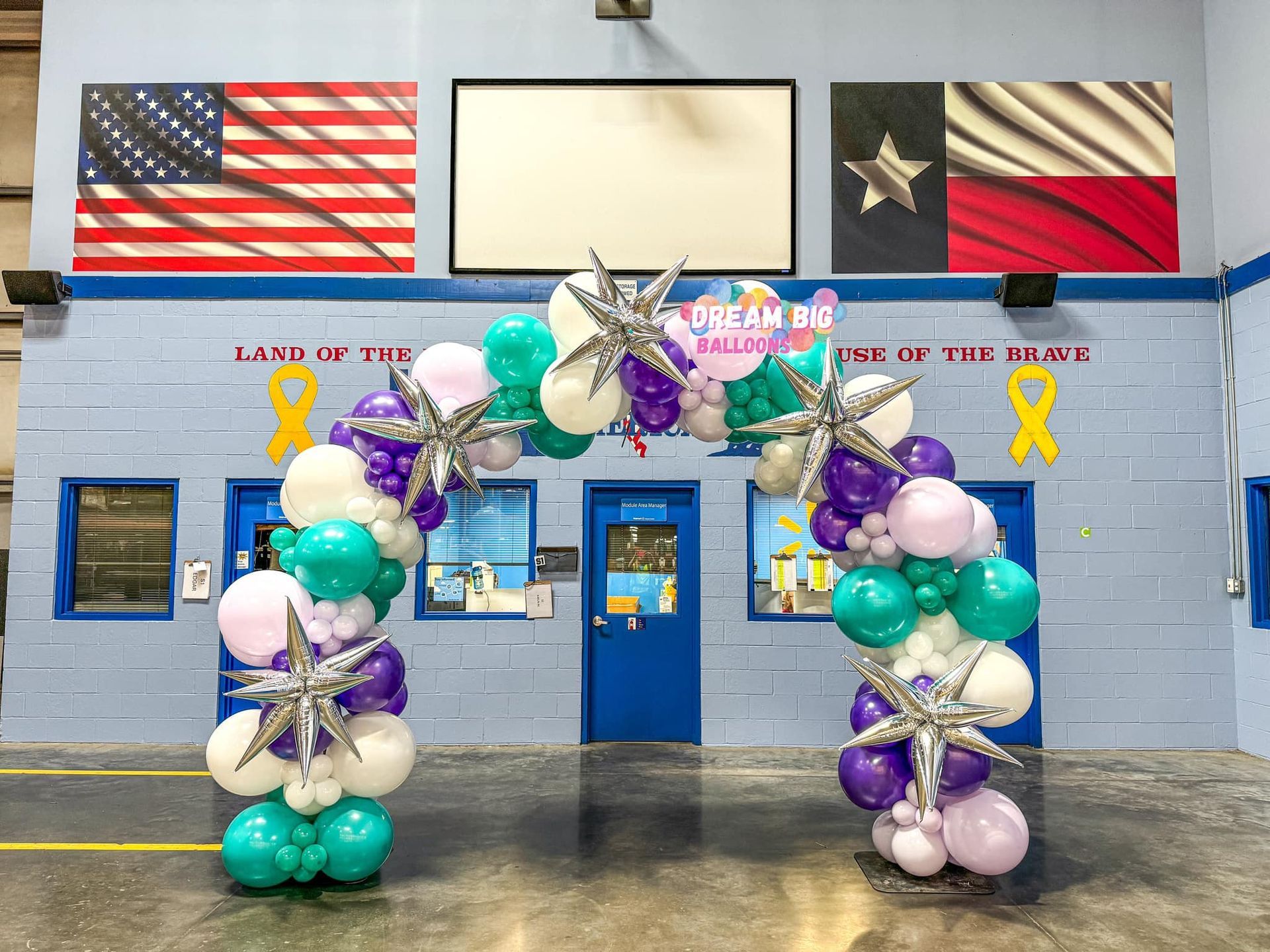 A bunch of balloons are sitting in front of a building.