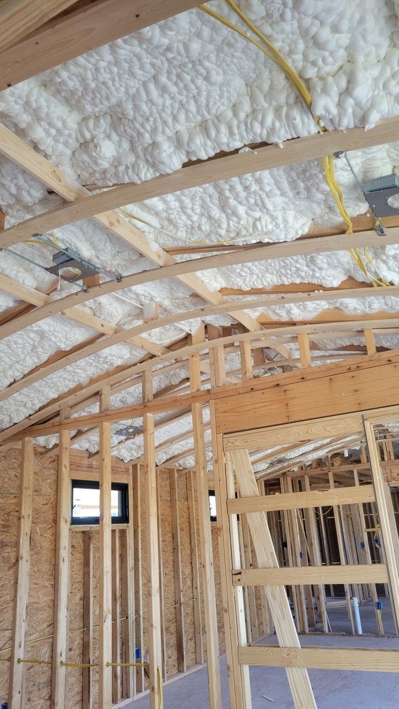 The inside of a house under construction with foam on the ceiling.