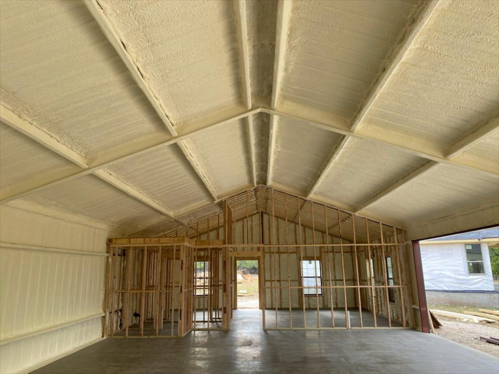 A garage is being built with a lot of insulation on the ceiling.
