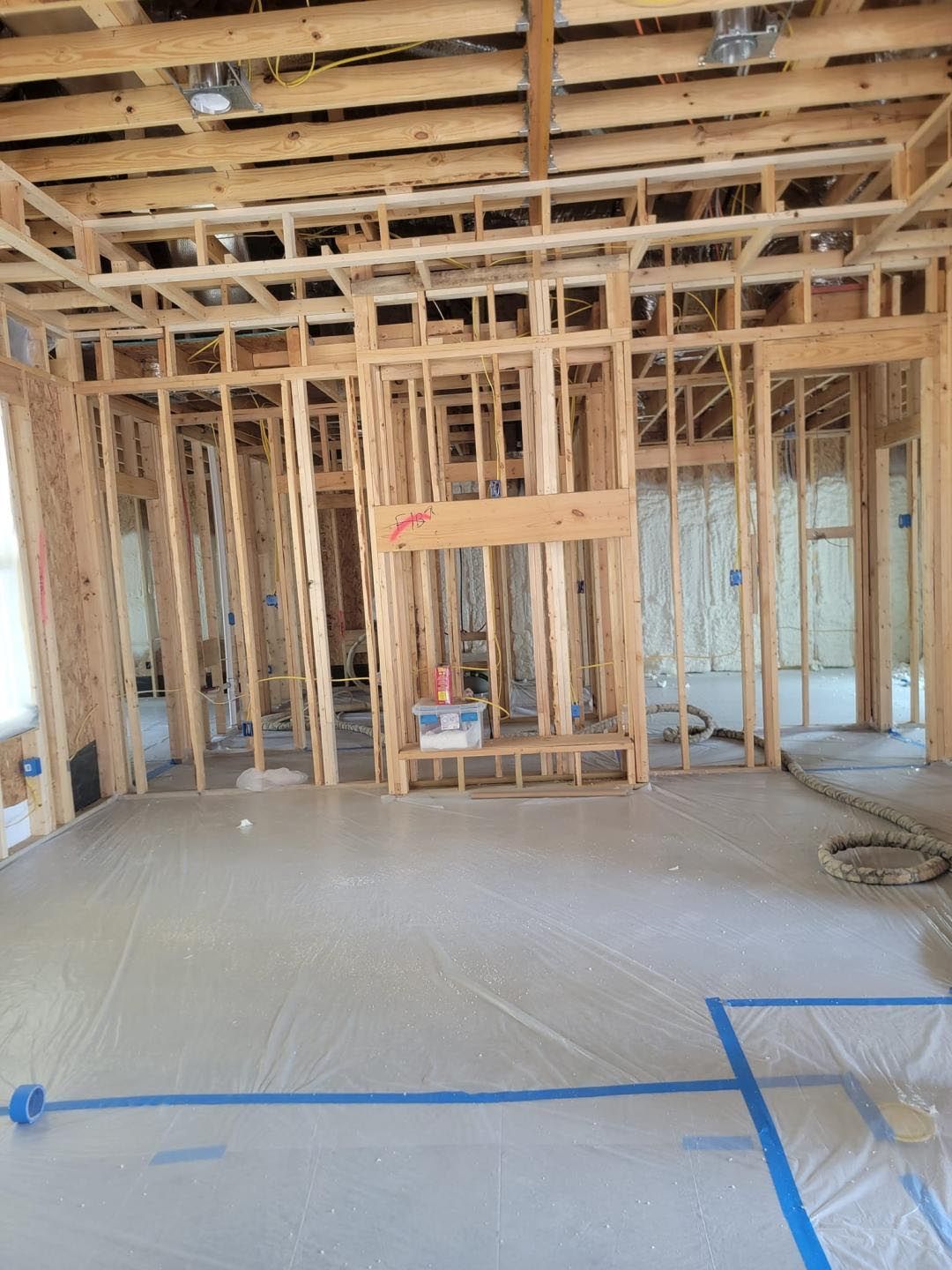 A room in a house under construction with a lot of wooden beams.
