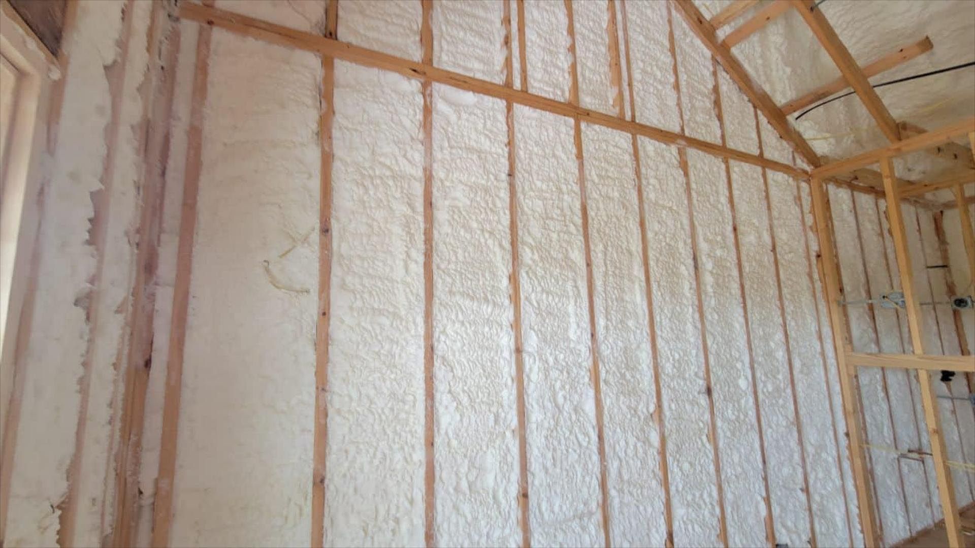 A room with a wall covered in foam and wooden beams.