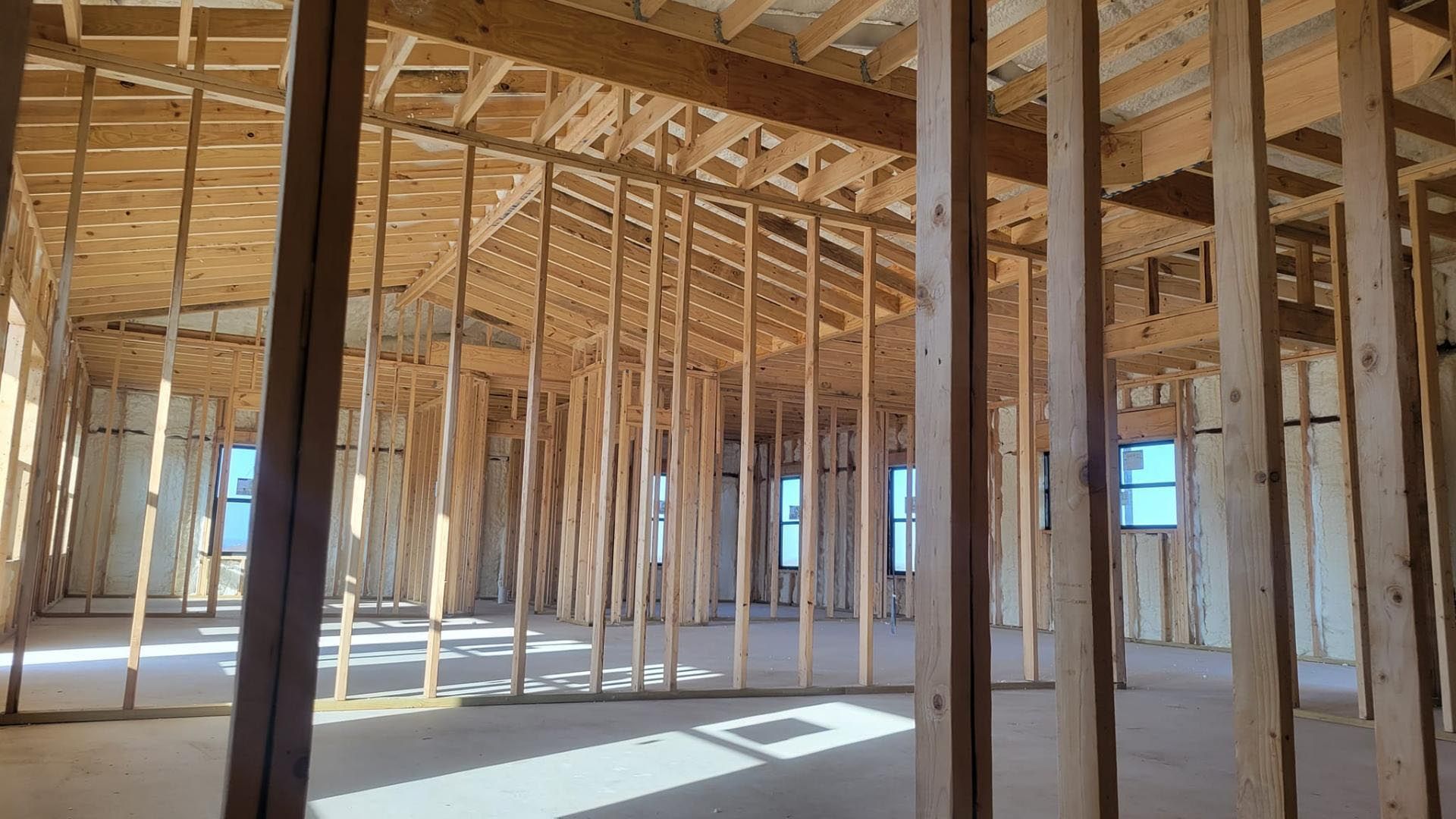 The inside of a building under construction with a lot of wooden beams.
