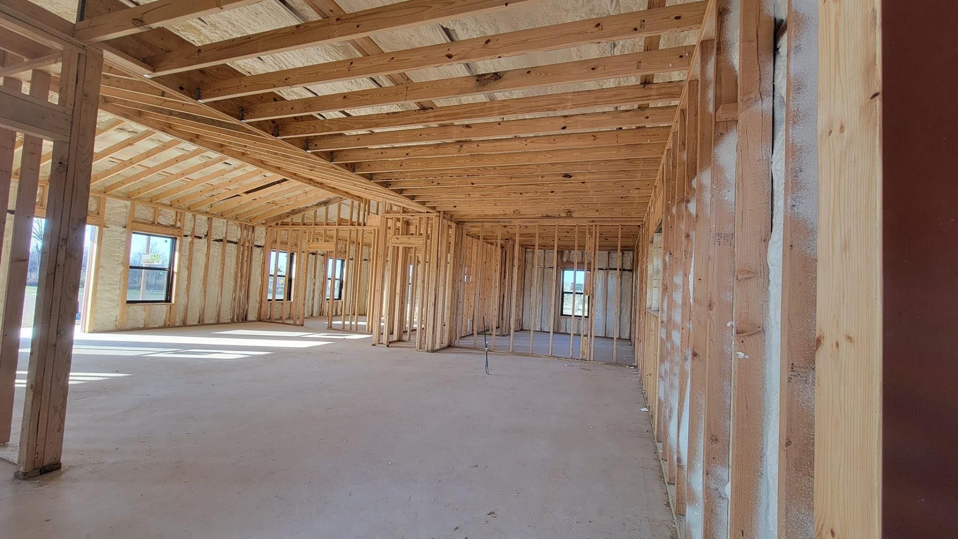 The inside of a building under construction with a lot of wooden beams.