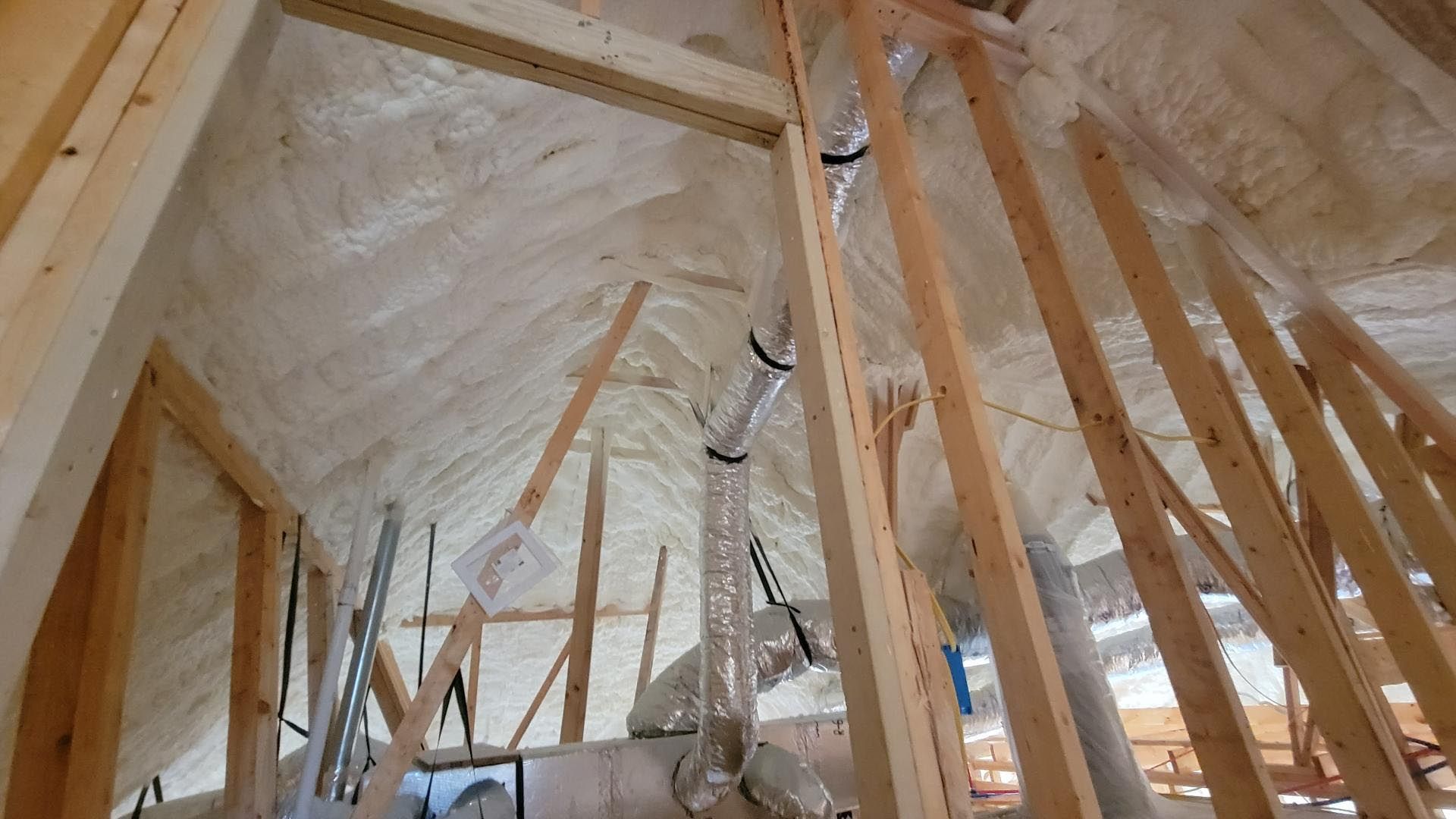 A room with a lot of wooden beams and foam on the ceiling.