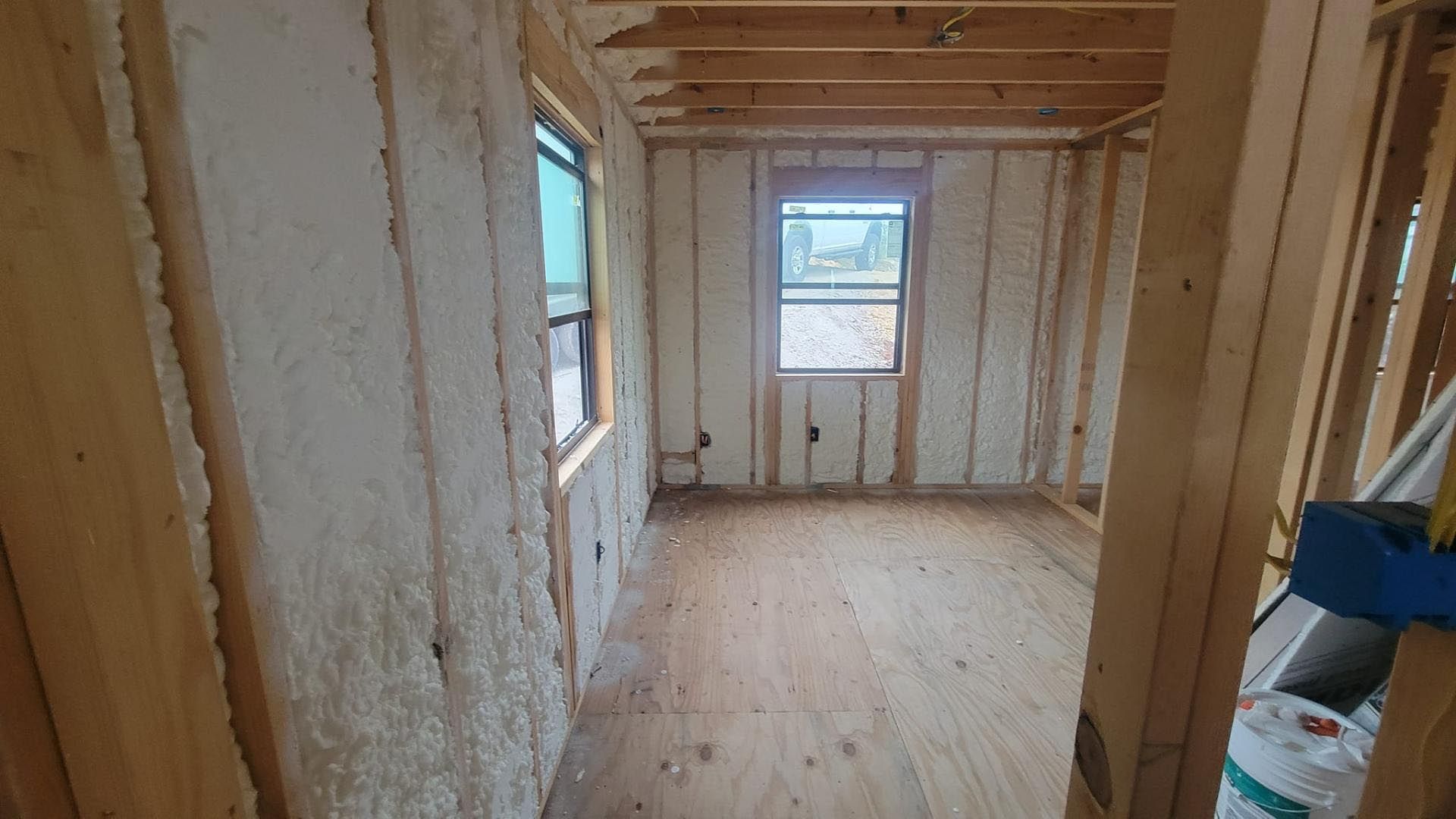 A room with foam insulation on the walls and a window.