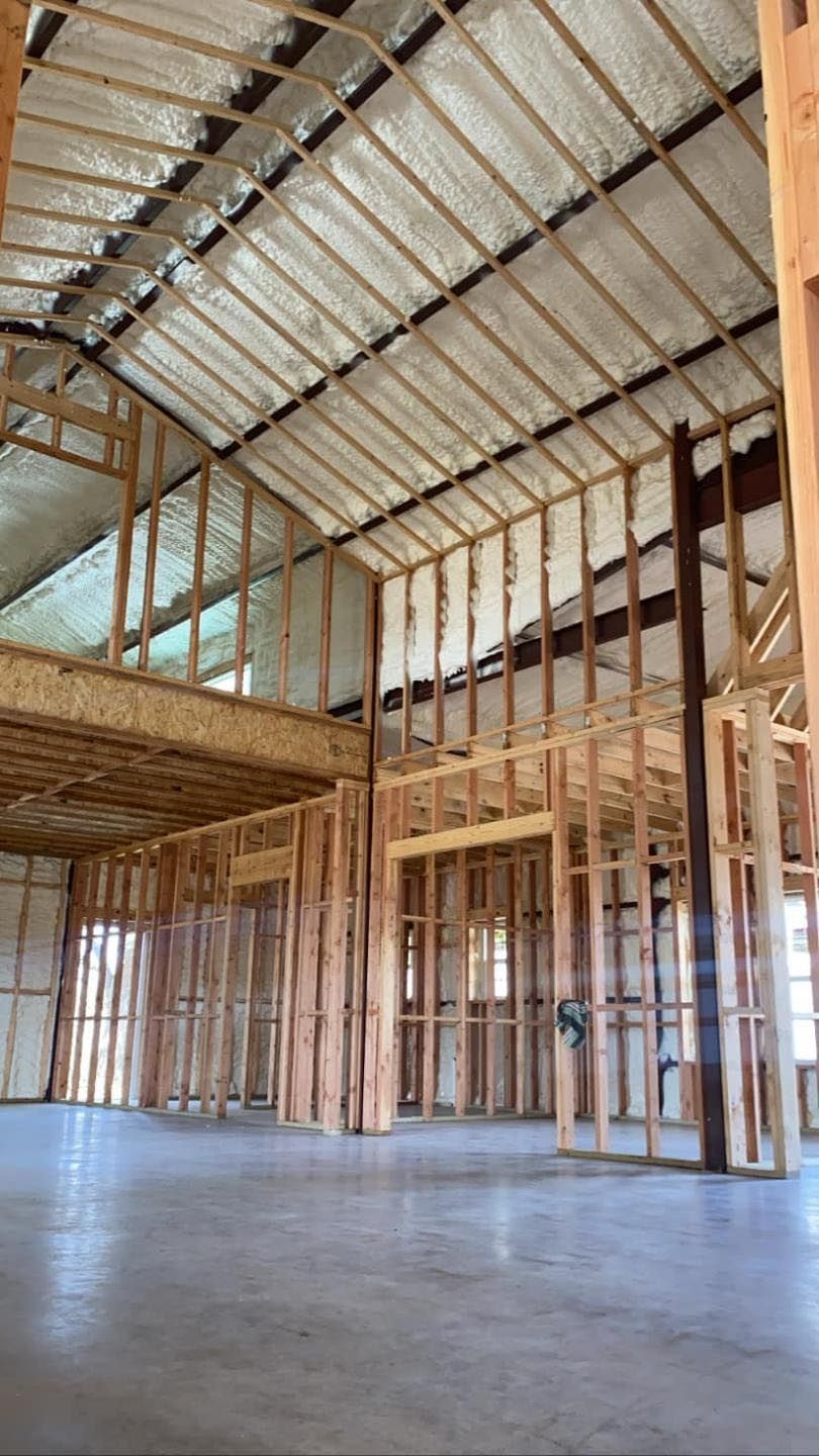 The inside of a building under construction with a lot of insulation on the ceiling.