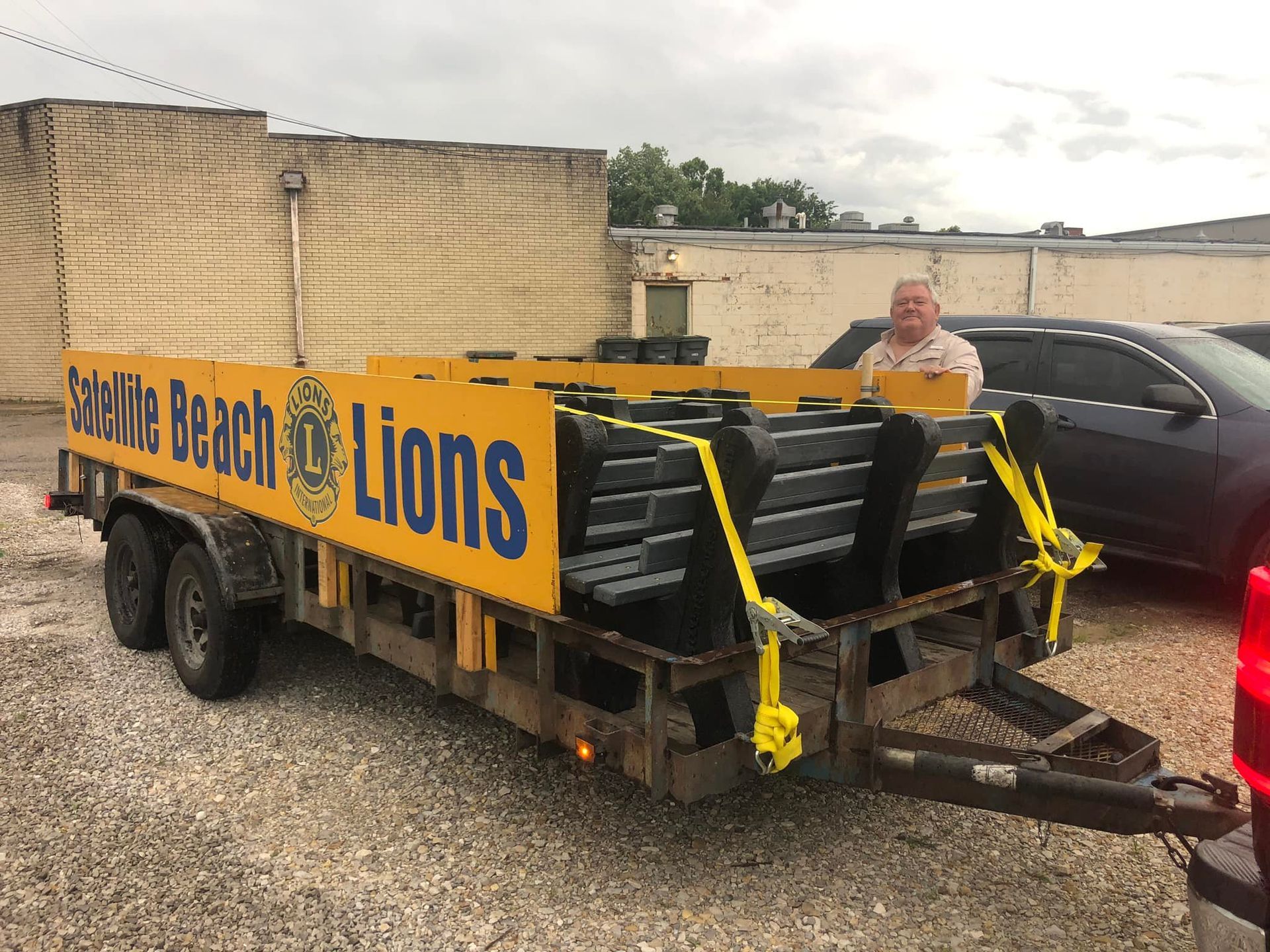 A man is standing next to a trailer that says beach of lions on it.